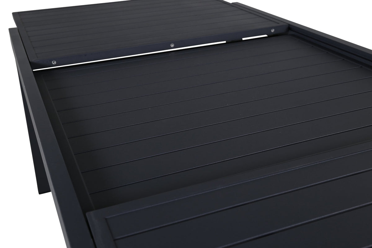 Vier schwarze Esszimmerstühle mit Polyesterbezug und pulverbeschichtetem Aluminiumgestell neben einem rechteckigen Esstisch aus schwarzem Aluminium.