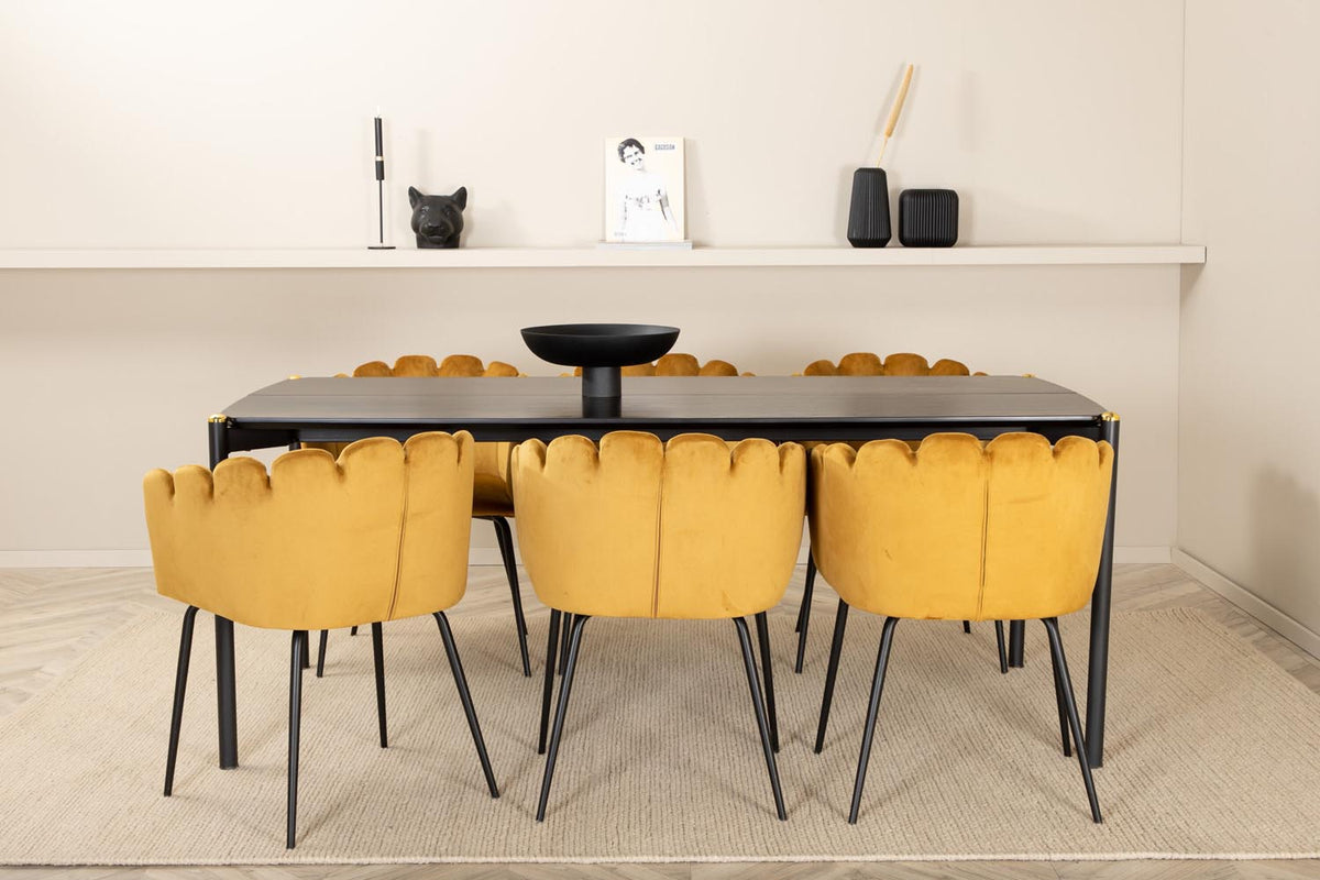 Schwarzer Esstisch aus MDF mit Furnier und Metallbeinen, kombiniert mit sechs Stühlen mit gelbem Samtbezug und schwarzen Metallbeinen.