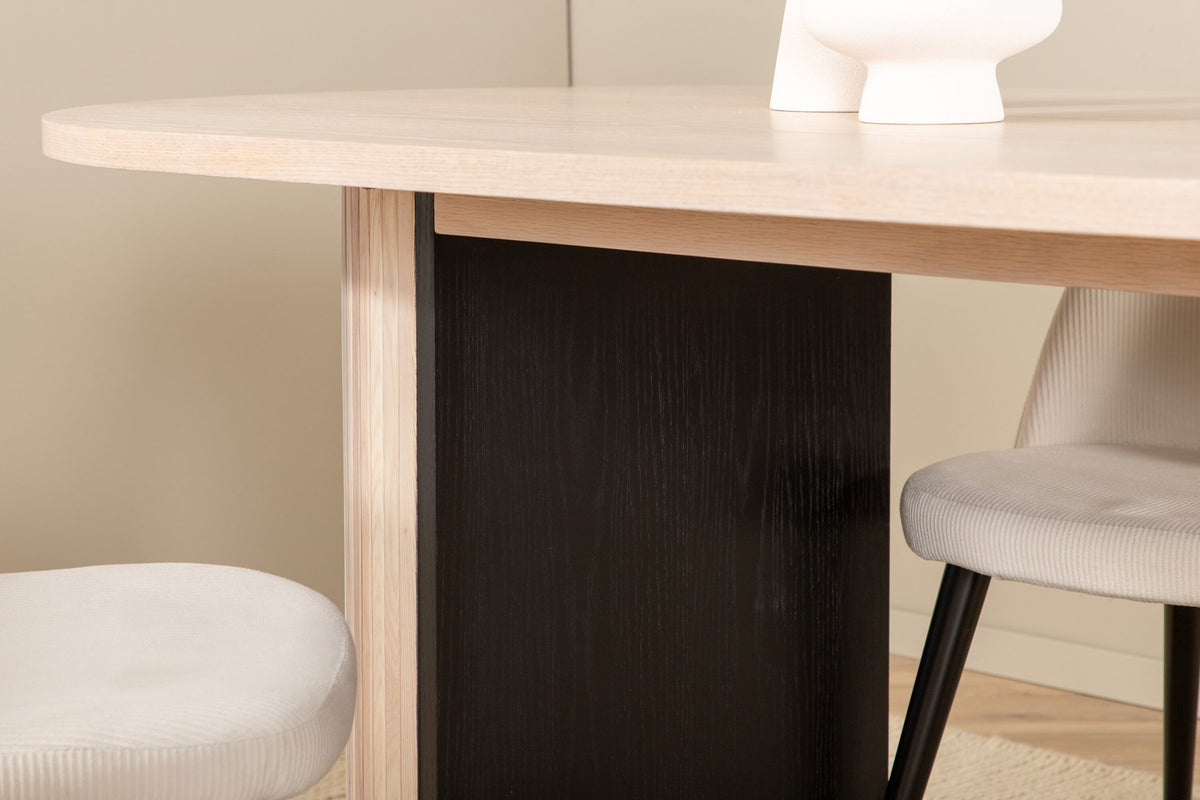 Ovaler Esstisch mit weiss lasierter MDF-Tischplatte und vier Samtstühlen mit schwarzen Stahlbeinen, cremefarbenes Esszimmerset.