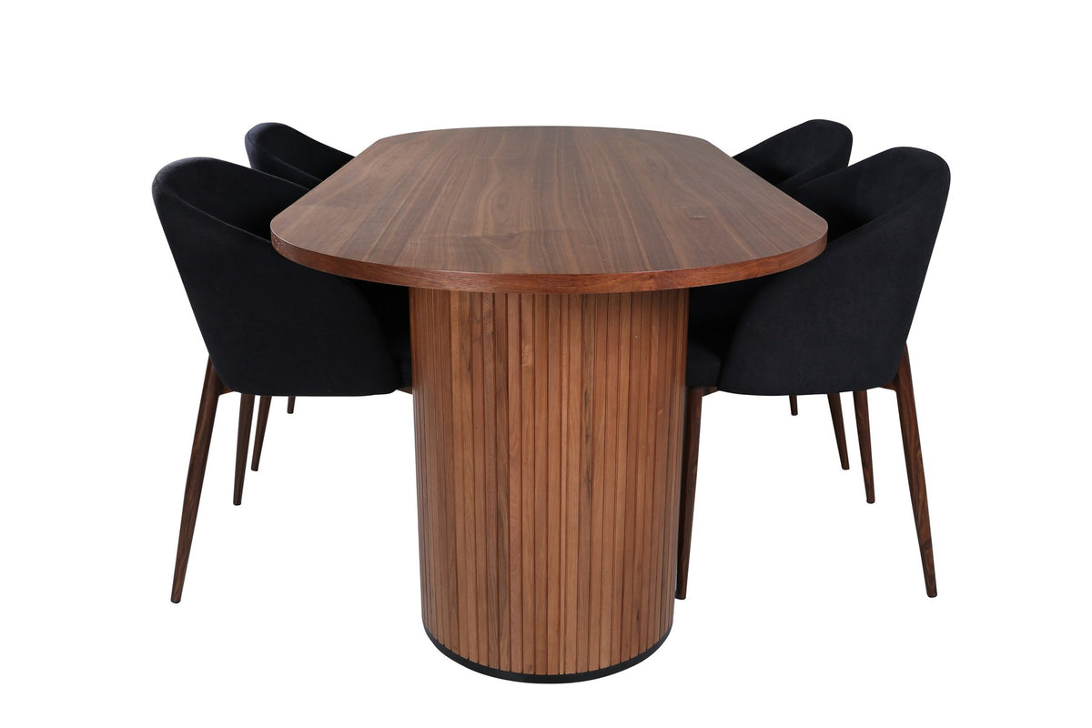 Ovaler Esstisch mit Nussbaum-MDF-Furnierplatte und Stahlgestell, daneben zwei schwarze Polsterstühle mit Metallbeinen im Esszimmer.