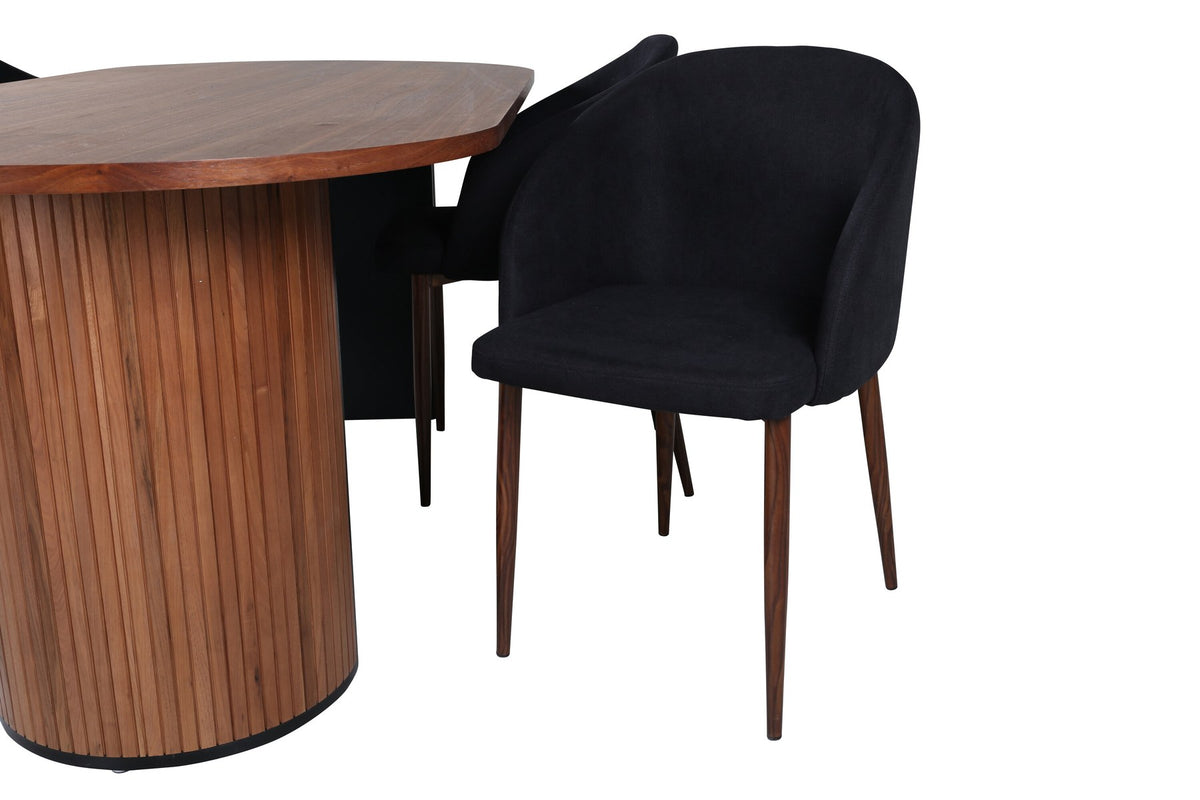 Ovaler Esstisch mit Nussbaum-MDF-Furnierplatte und Stahlgestell, daneben zwei schwarze Polsterstühle mit Metallbeinen im Esszimmer.