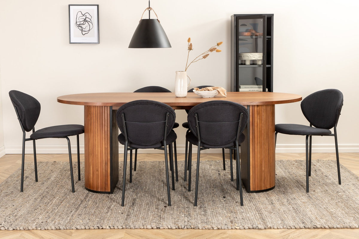 Ovaler Esstisch aus Nussbaum-MDF mit Furnier und Stahlbeinen, dazu zwei schwarze Polsterstühle mit Metallbeinen im Set.