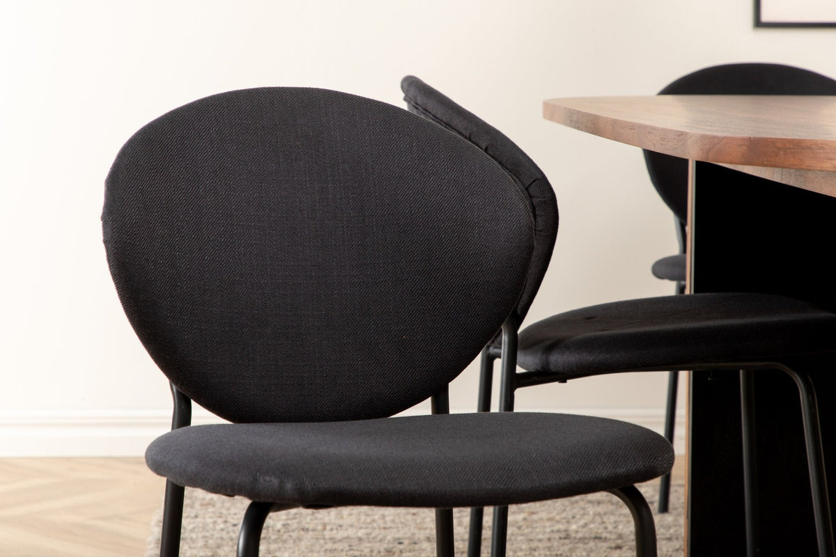 Ovaler Esstisch aus Nussbaum-MDF mit Furnier und Stahlbeinen, dazu zwei schwarze Polsterstühle mit Metallbeinen im Set.