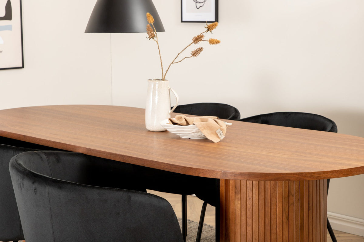 Ovaler Esstisch aus Nussbaum-MDF mit Furnier und vier schwarzen Esszimmerstühlen mit Samtsitz und schmalen Eisenbeinen von Venture Home.