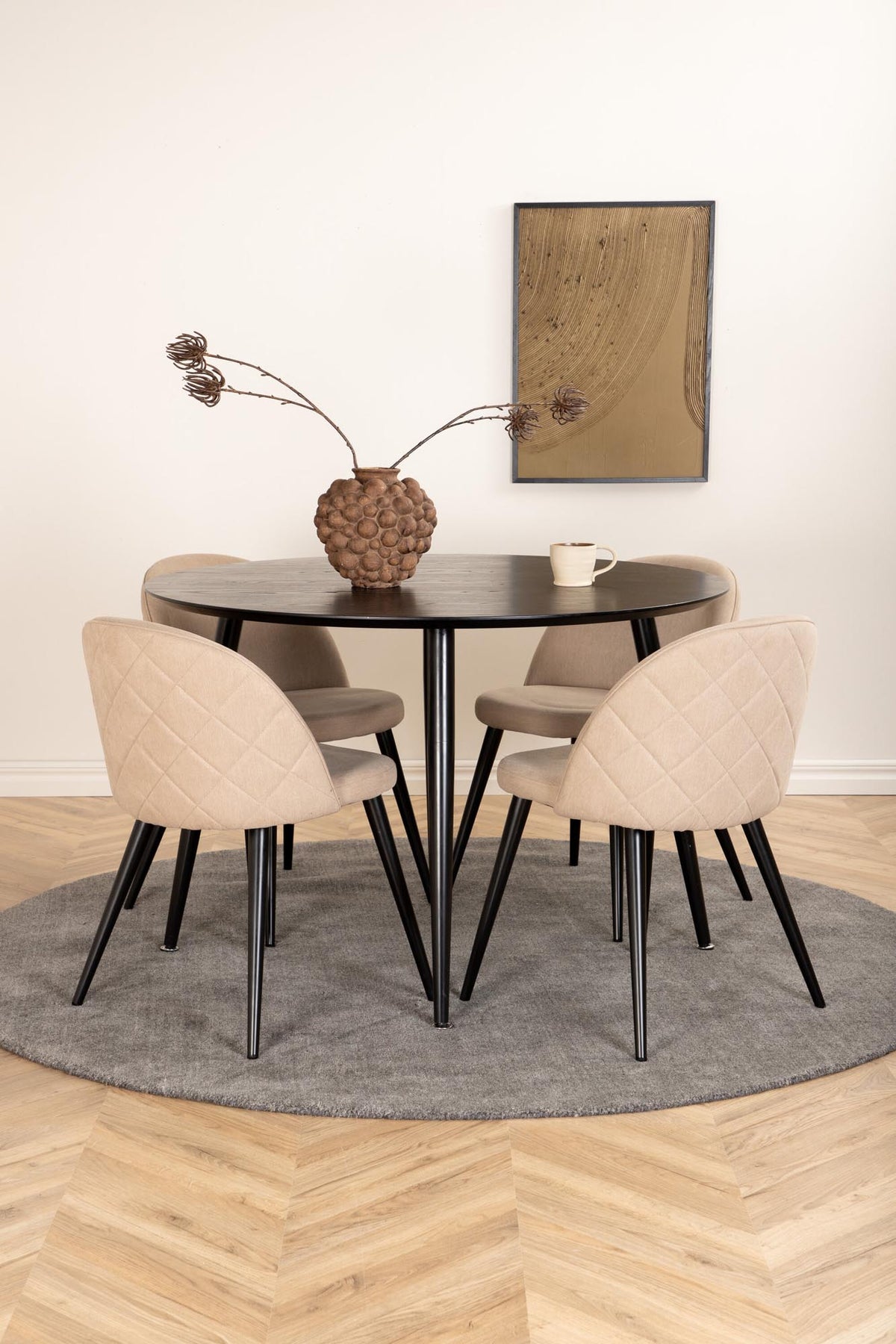 Rundes Dipp Esszimmerset: Esstisch ⌀115 cm mit schwarzem Furnier und schwarzen Beinen, dazu vier Velvet-Stühle mit schwarz-grauem Mikrofaserbezug.