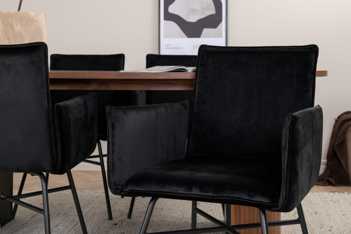 Ovaler Esstisch aus MDF mit Nussbaum-Furnier, 200x90 cm, kombiniert mit vier schwarzen Esszimmerstühlen mit pulverbeschichteter Oberfläche.