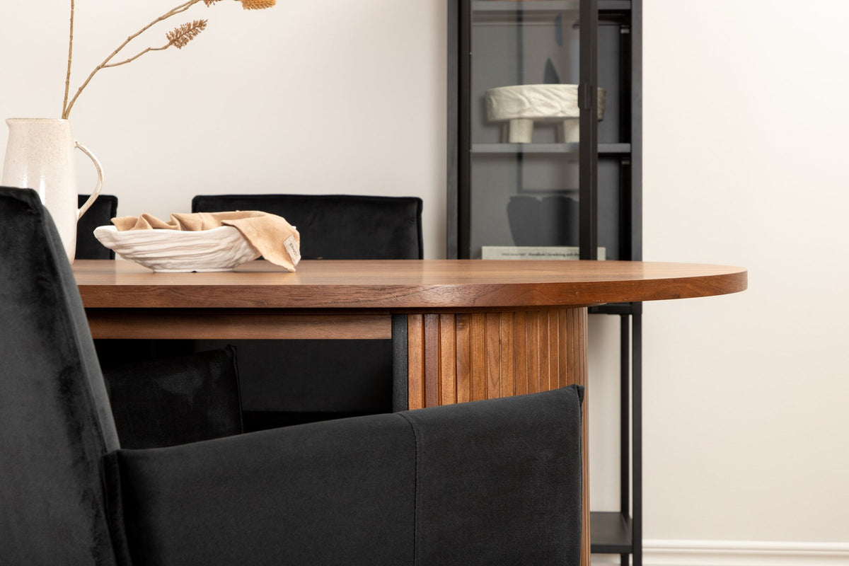 Ovaler Esstisch aus MDF mit Nussbaum-Furnier, 200x90 cm, kombiniert mit vier schwarzen Esszimmerstühlen mit pulverbeschichteter Oberfläche.