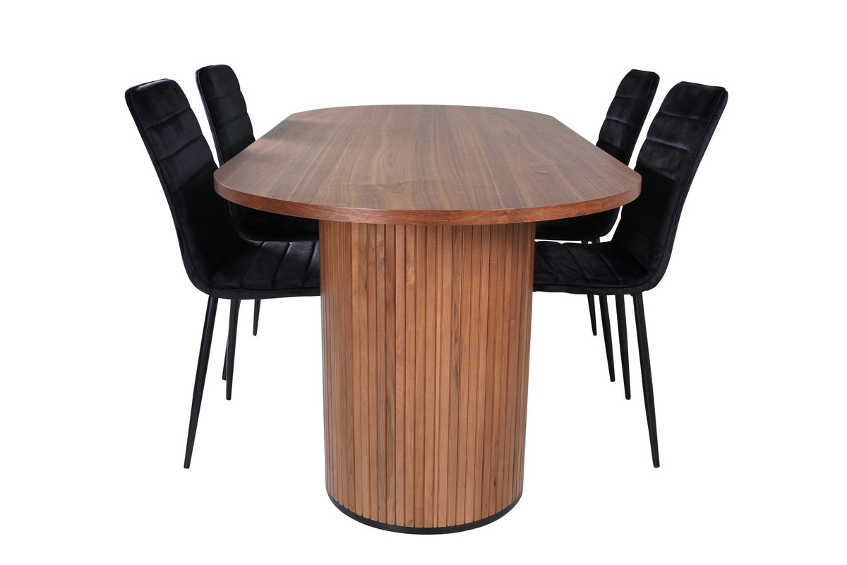 Ovaler Esstisch mit Nussbaum-Tischplatte aus MDF und Furnier sowie zwei schwarze Esszimmerstühle mit Samtsitz und schmalen Beinen.