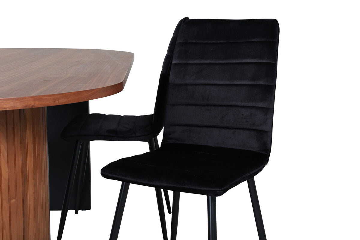 Ovaler Esstisch mit Nussbaum-Tischplatte aus MDF und Furnier sowie zwei schwarze Esszimmerstühle mit Samtsitz und schmalen Beinen.