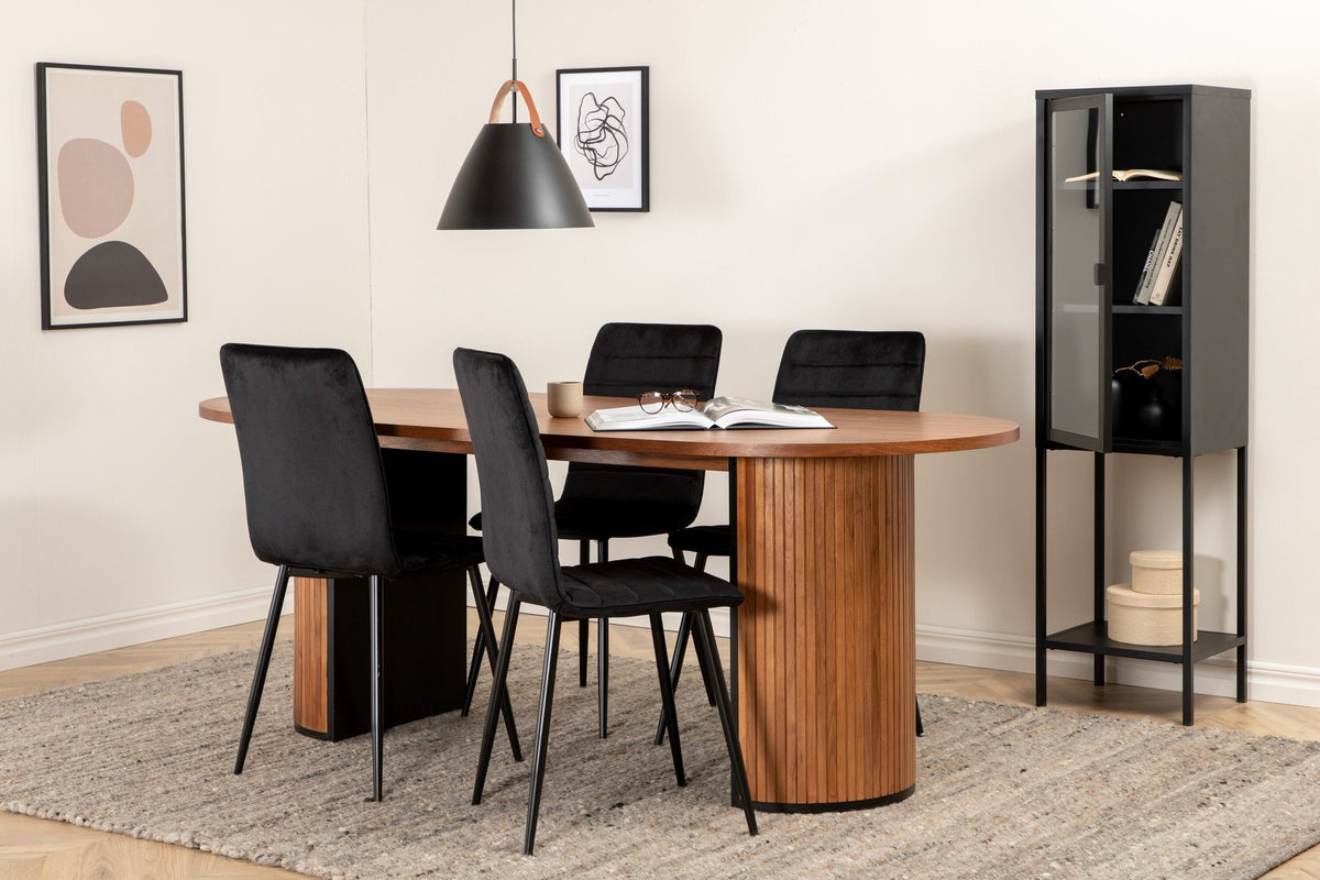 Ovaler Esstisch mit Nussbaum-Tischplatte aus MDF und Furnier sowie zwei schwarze Esszimmerstühle mit Samtsitz und schmalen Beinen.