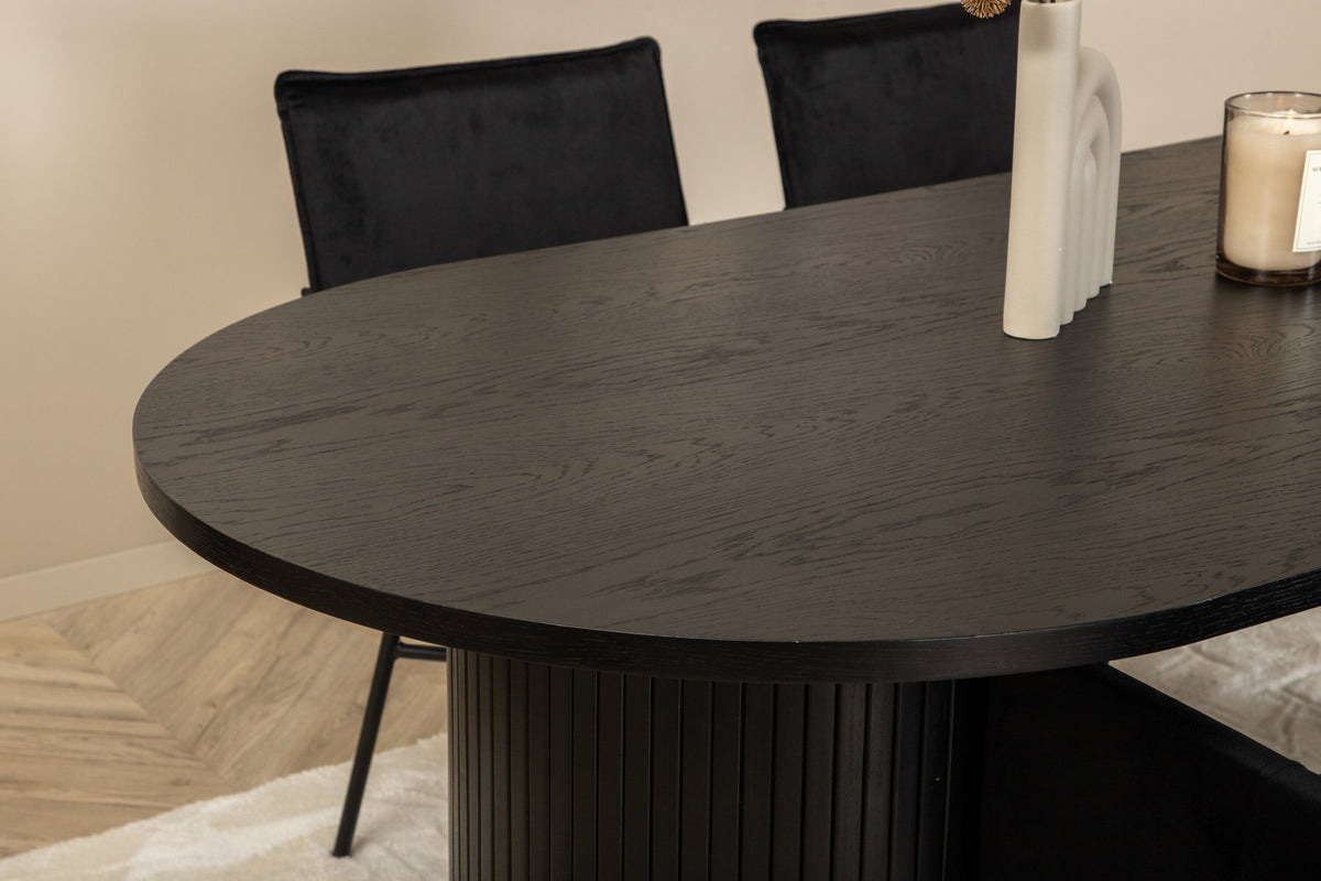 Ovaler Esstisch 200x90 cm aus MDF mit schwarzem Furnier und vier Esszimmerstühle mit kupferfarbenen Beinen und schwarzem Samtbezug.