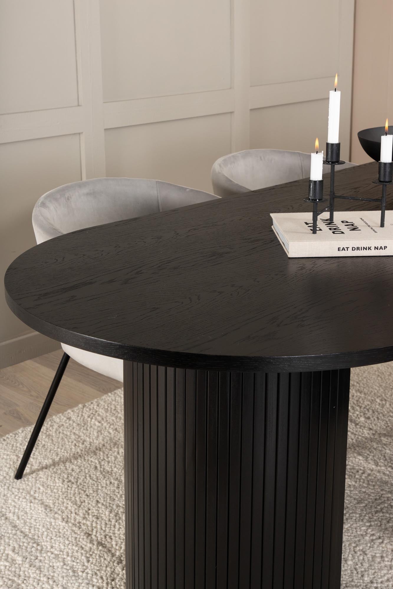 Modernes Esszimmerset mit ovalem Tisch (200x90cm) in edlem Schwarz und 4 bequemen grauen Samtstühlen. Ideal für stilvolle Esszimmergestaltung.