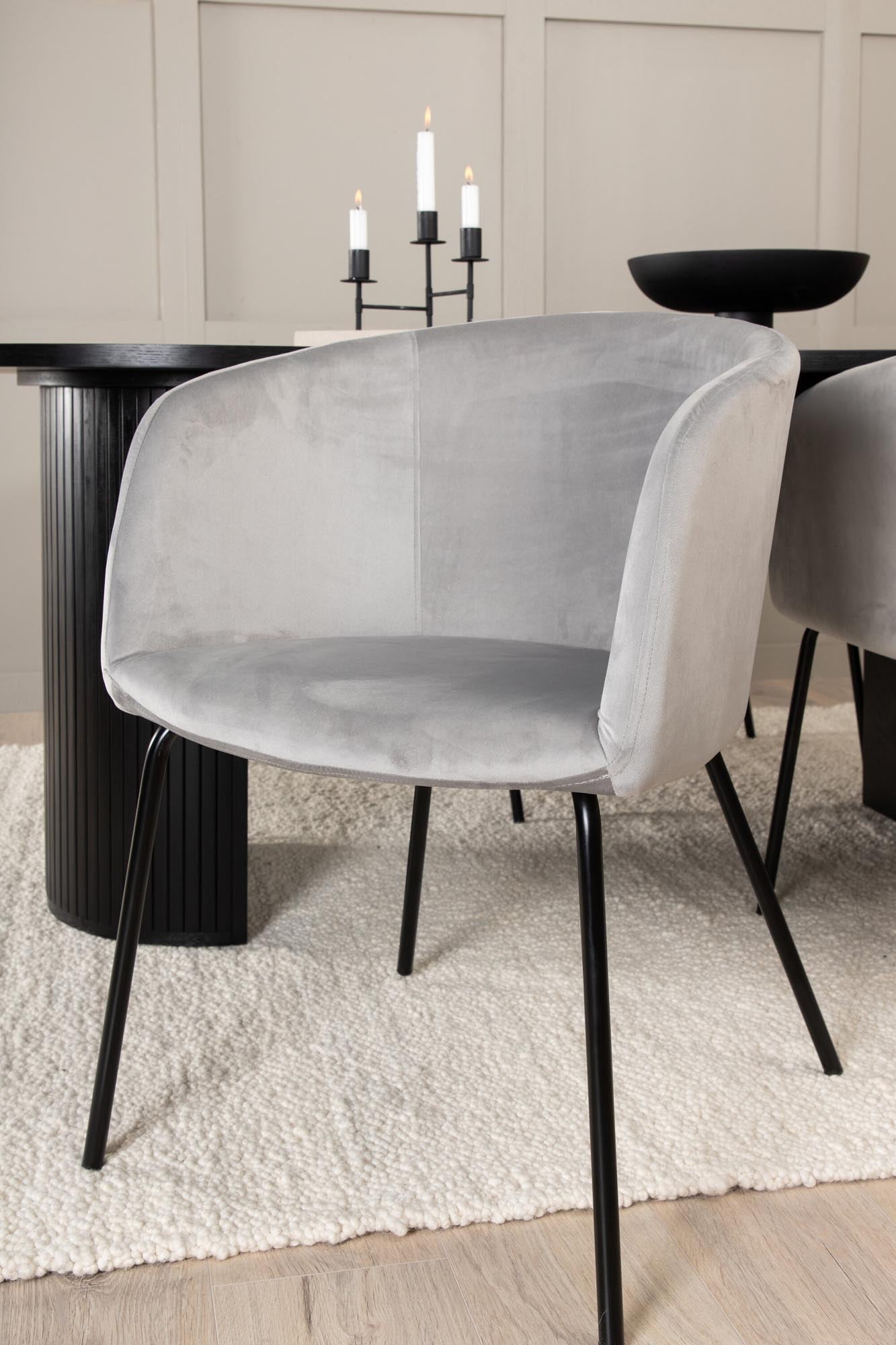 Elegantes Esszimmerset mit ovalem Tisch (200x90cm) in Schwarz und 4 komfortablen grauen Samtstühlen. Perfekt für stilvolle Esszimmer.