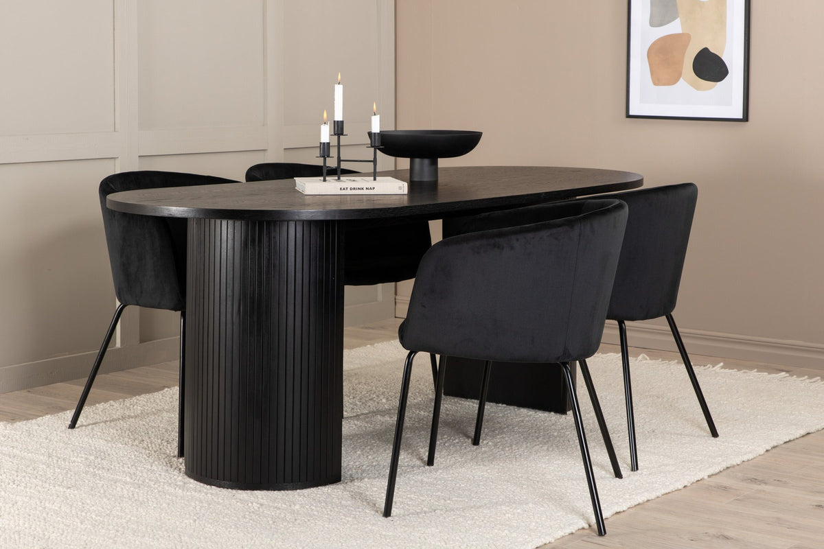 Schwarzes Esszimmerset aus MDF mit ovalem Esstisch und vier Stühlen mit Samtsitz und schlankem Eisengestell, Ansicht von vorne.