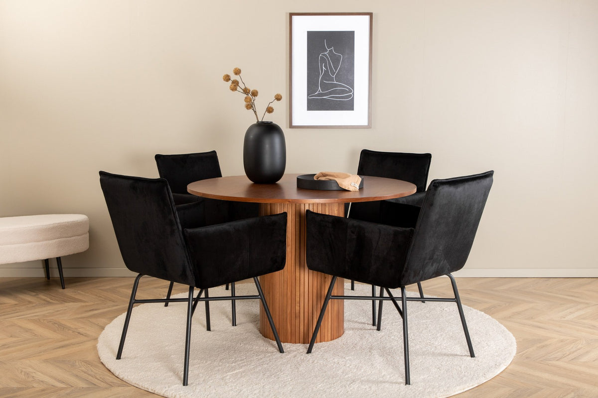 Rundes Esszimmerset mit Nussbaum-Tischplatte Ø110cm aus MDF und vier schwarzen Stühlen mit Samtsitz und Beinen aus Eisen.