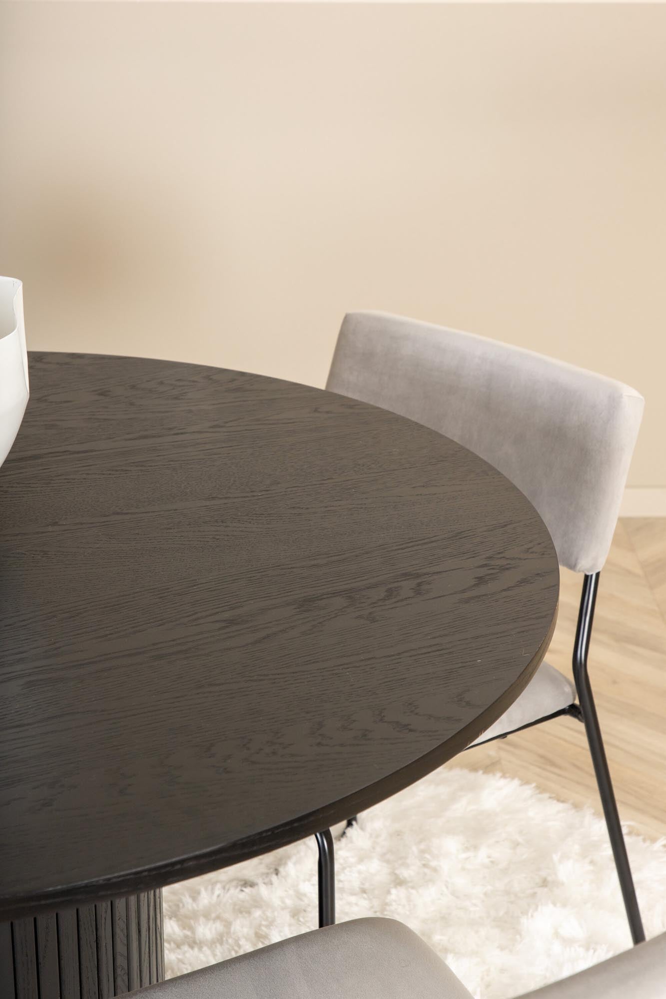 Modernes Esszimmerset mit runder MDF-Tischplatte und 4 eleganten Samtstühlen. Ideal für stilvolle Dinner und gesellige Zusammenkünfte.