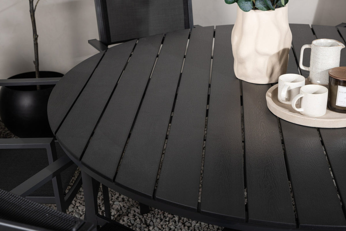 Runder schwarzer Gartentisch aus Aintwood mit Aluminiumgestell und zwei stapelbaren Stühlen mit Textilene-Bezug im Aussenbereich.