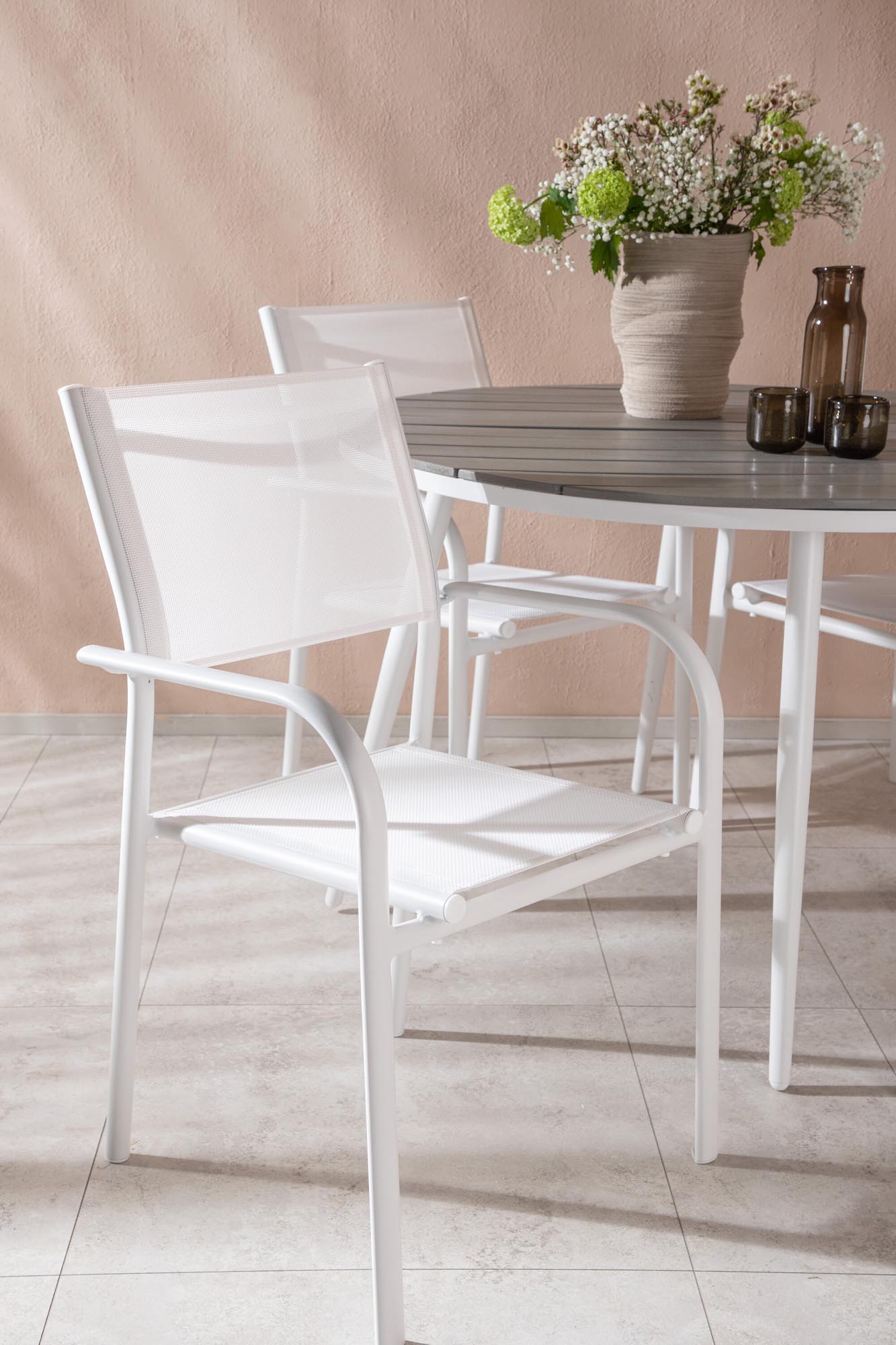 Moderner Break Esstisch mit 4 stapelbaren Santorini Armstühlen.