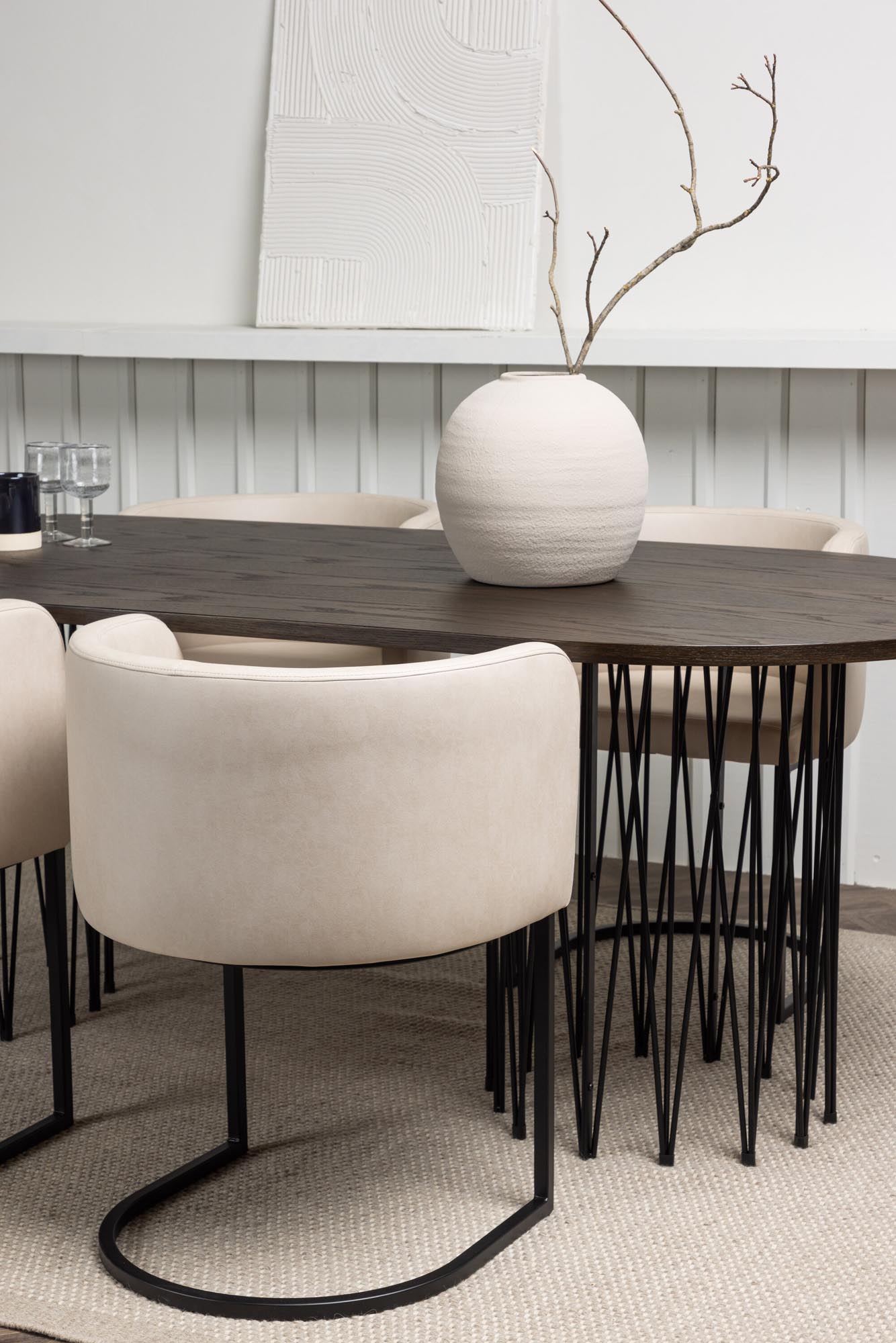 Elegantes Esszimmerset mit ovalem MDF-Tisch und stilvollen Metallgestellen. Bequeme, gepolsterte Stühle in beigem Stoff für höchsten Komfort.