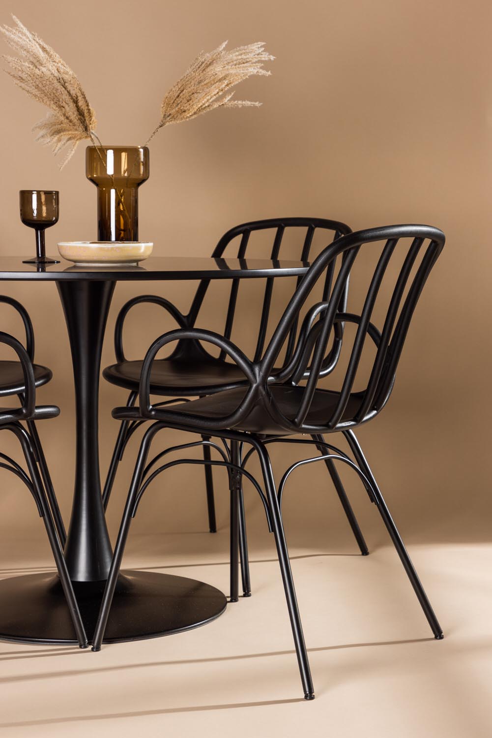 Schwarzes Esszimmerset Glade mit rundem MDF-Tisch und vier Dyrön-Stühlen aus Kunststoff und Stahl, skandinavisches Design.