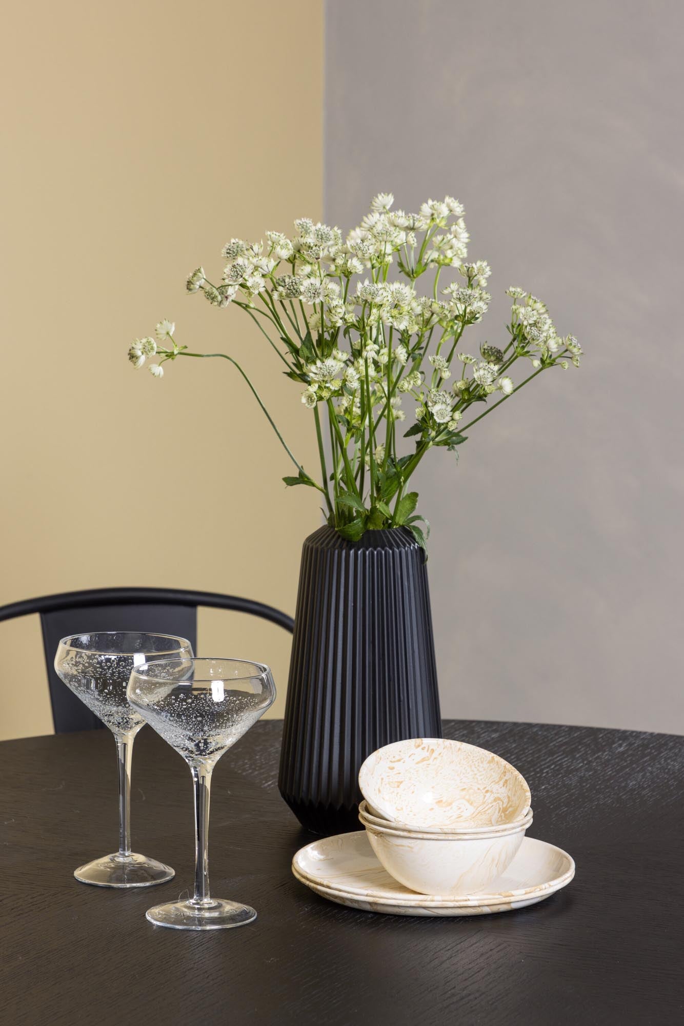 Modernes Esszimmerset mit runden Tisch und bequemen Stühlen im Industriedesign. Ideal für gesellige Abende und stilvolle Essbereiche.