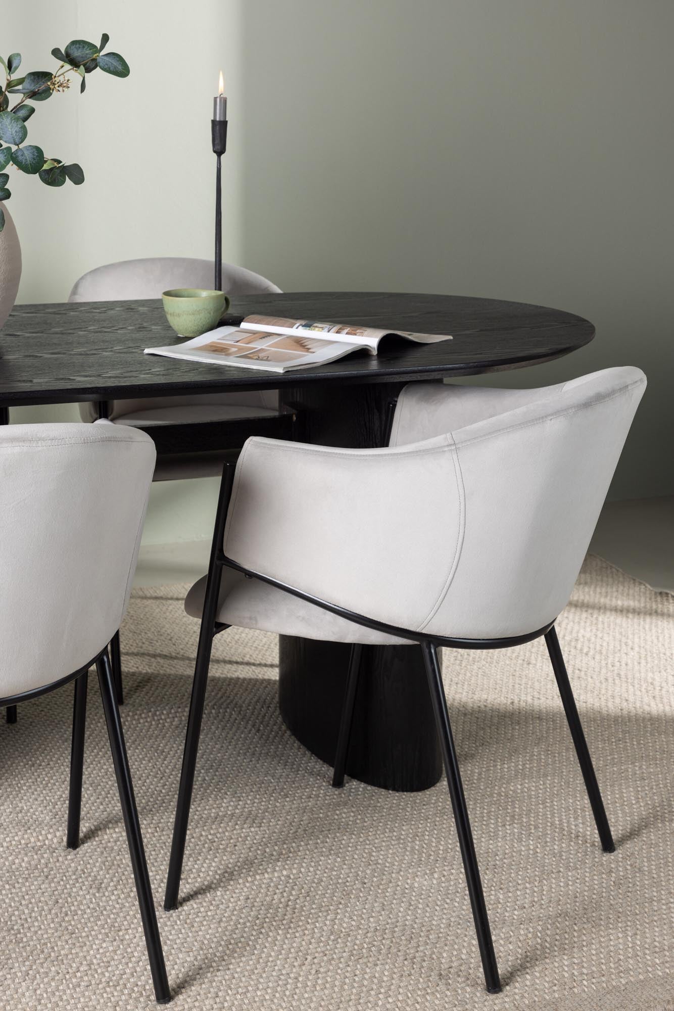 Modernes Esszimmerset mit ovalem Tisch und stilvollen Stühlen aus Samt. Ideal für gesellige Abende und elegantes Ambiente.