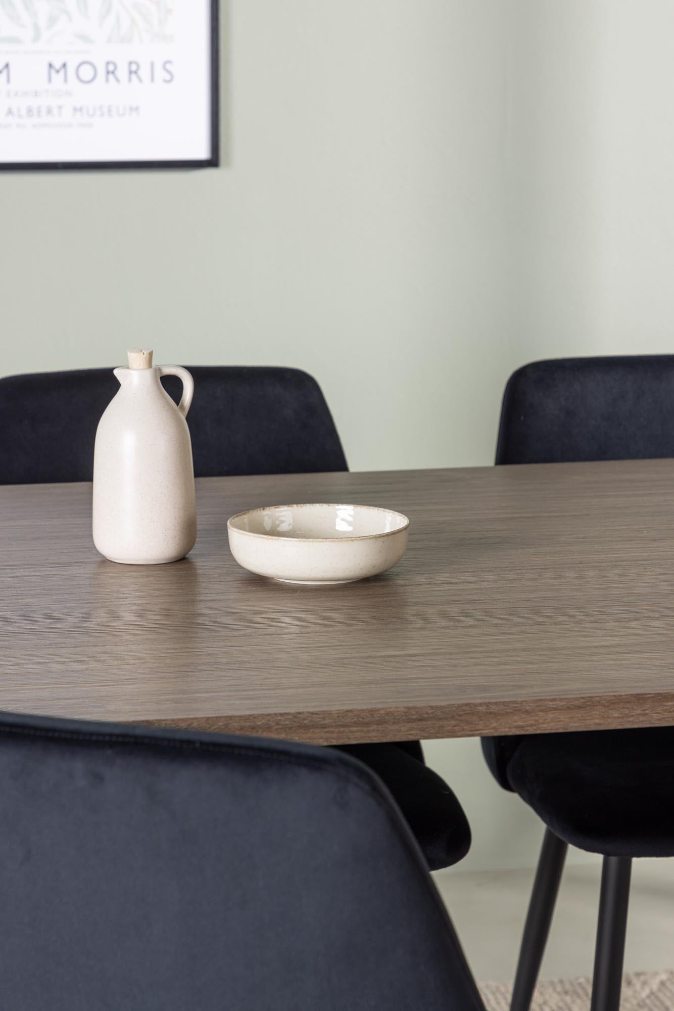 Stilvolles Esszimmerset: Moderner Esstisch mit ovaler MDF-Platte, gepolsterte Samtstühle, harmonische Erdtöne für ein einladendes Ambiente.