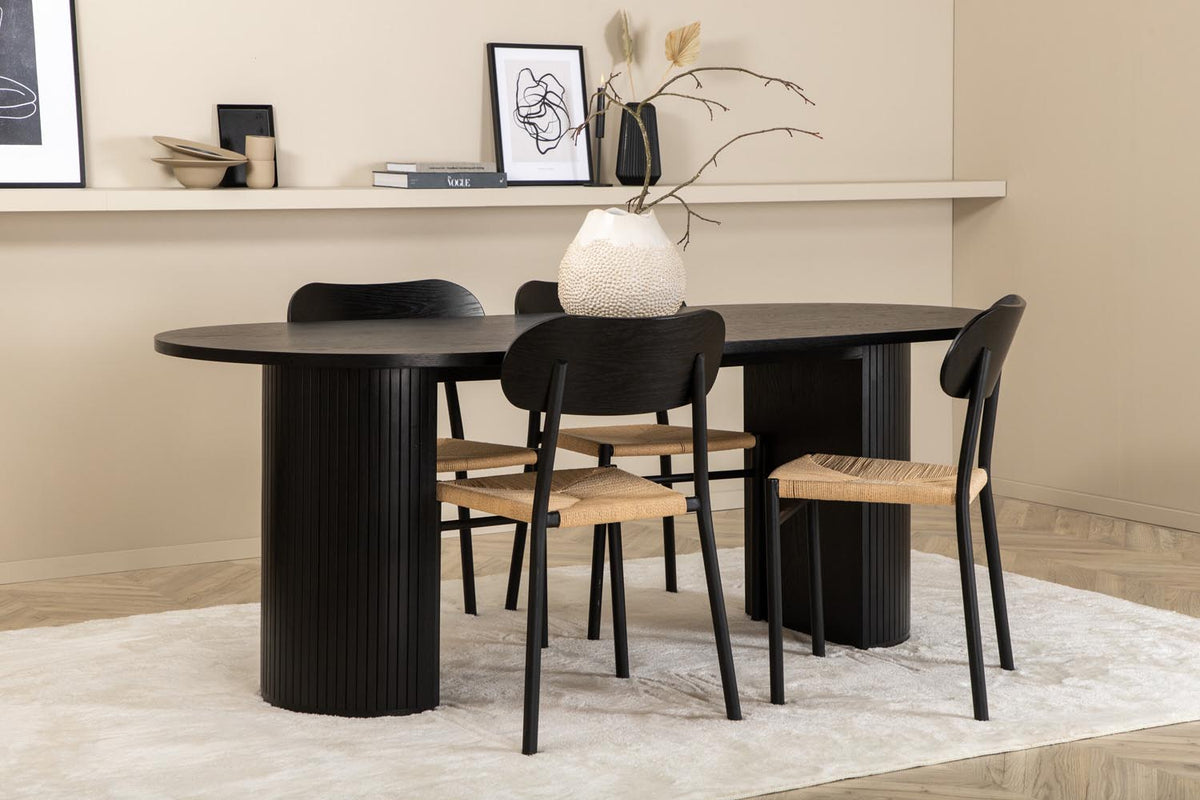 Rundes Esszimmerset Bianca mit Stuhl Polly: Tisch aus MDF und Furnier in Walnuss, vier schwarze Stühle mit Metallbeinen und Seilsitzen.