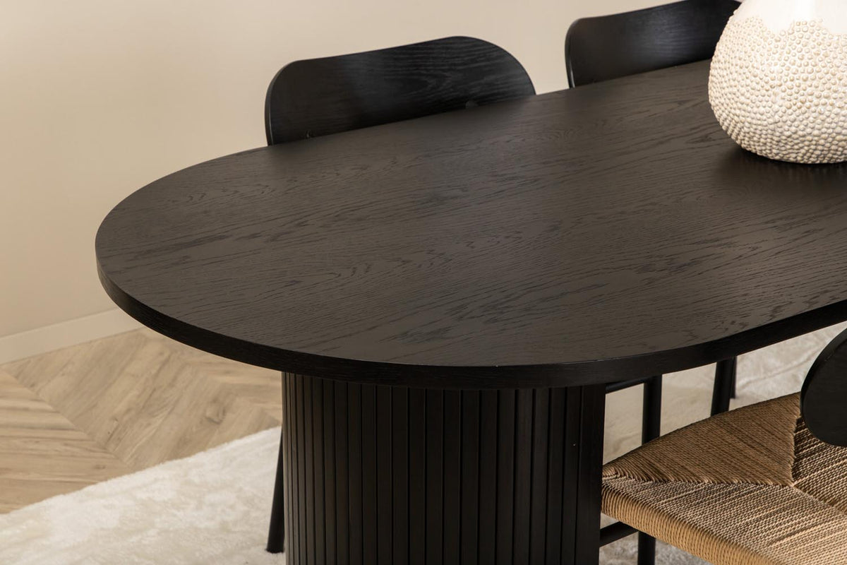 Rundes Esszimmerset Bianca mit Stuhl Polly: Tisch aus MDF und Furnier in Walnuss, vier schwarze Stühle mit Metallbeinen und Seilsitzen.