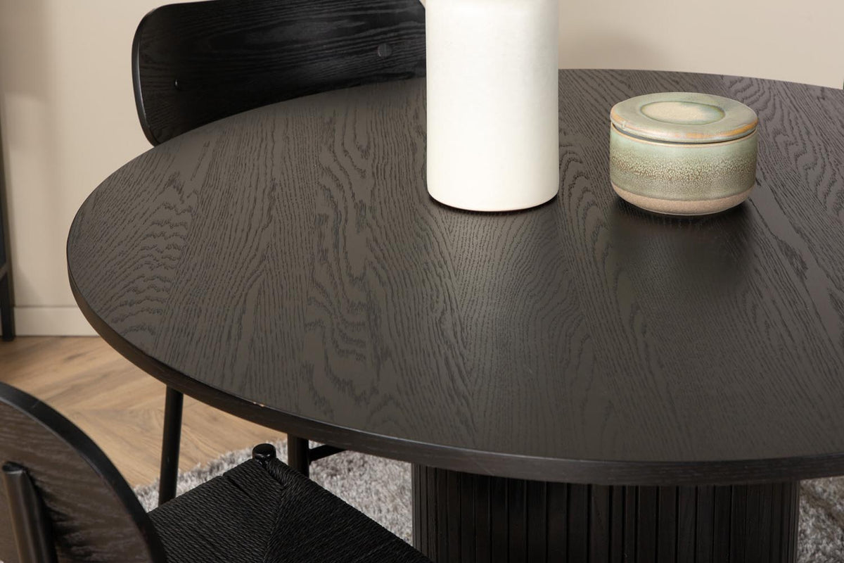 Rundes Esszimmerset Bianca mit Stuhl Polly: Tisch aus MDF und Furnier in Walnuss, vier schwarze Stühle mit Metallbeinen und Seilsitzen.