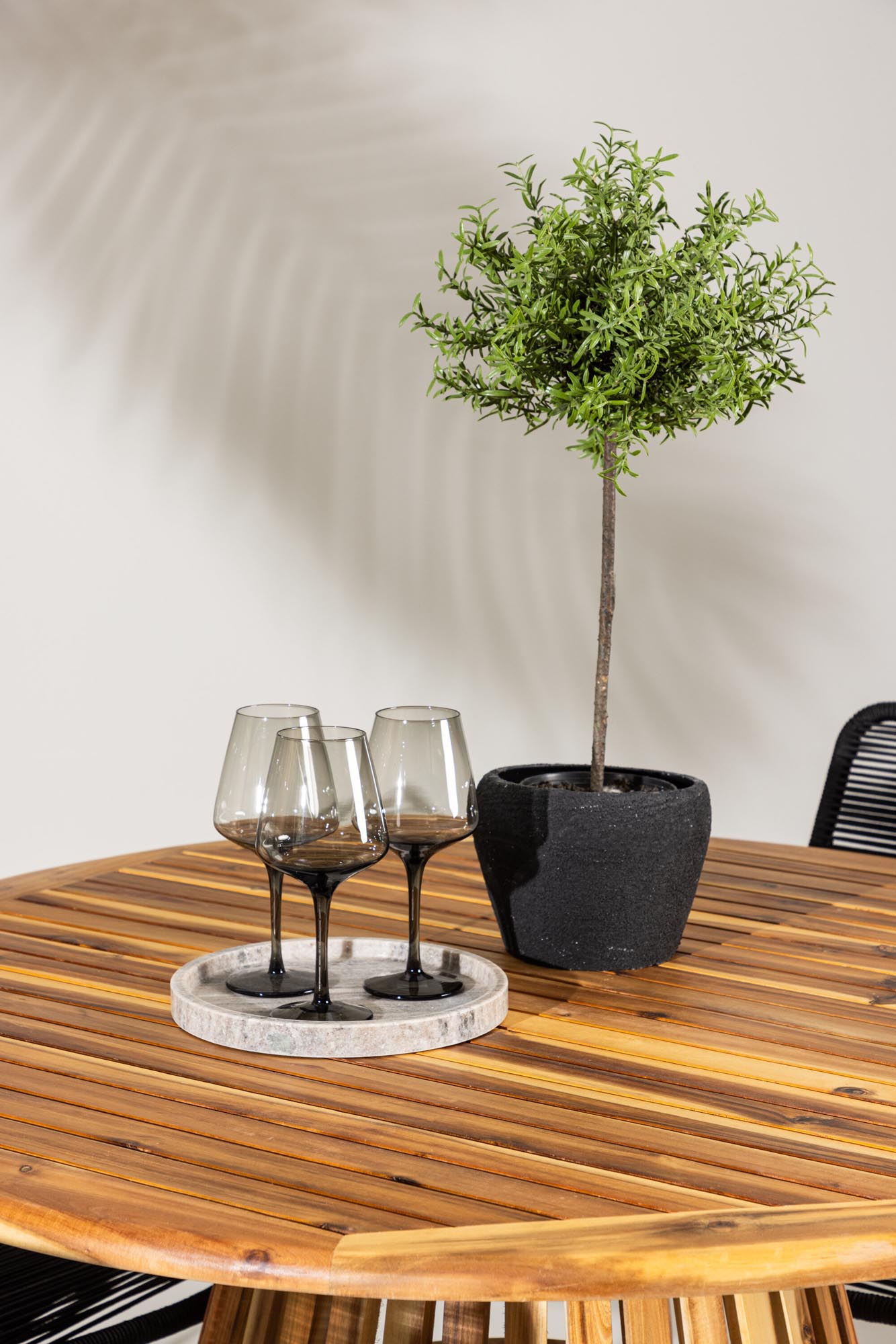 Rundes Gartenset mit modernem Design: Tisch und komfortable Armstühle, perfekt für entspannte Stunden im Freien.