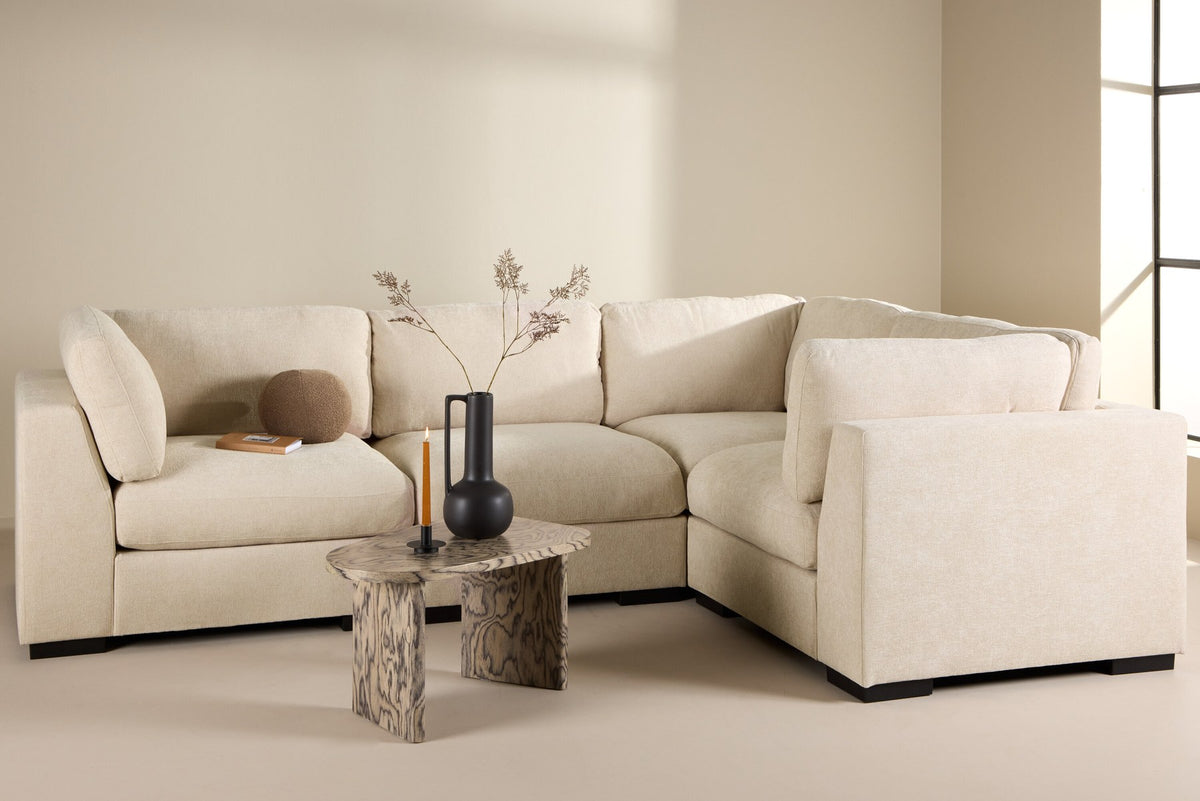 Ecksofa Salerno in Beige mit Polyesterbezug, beigen Kissen und schlanken schwarzen Kunststoffbeinen, Sitzhöhe 47 cm.