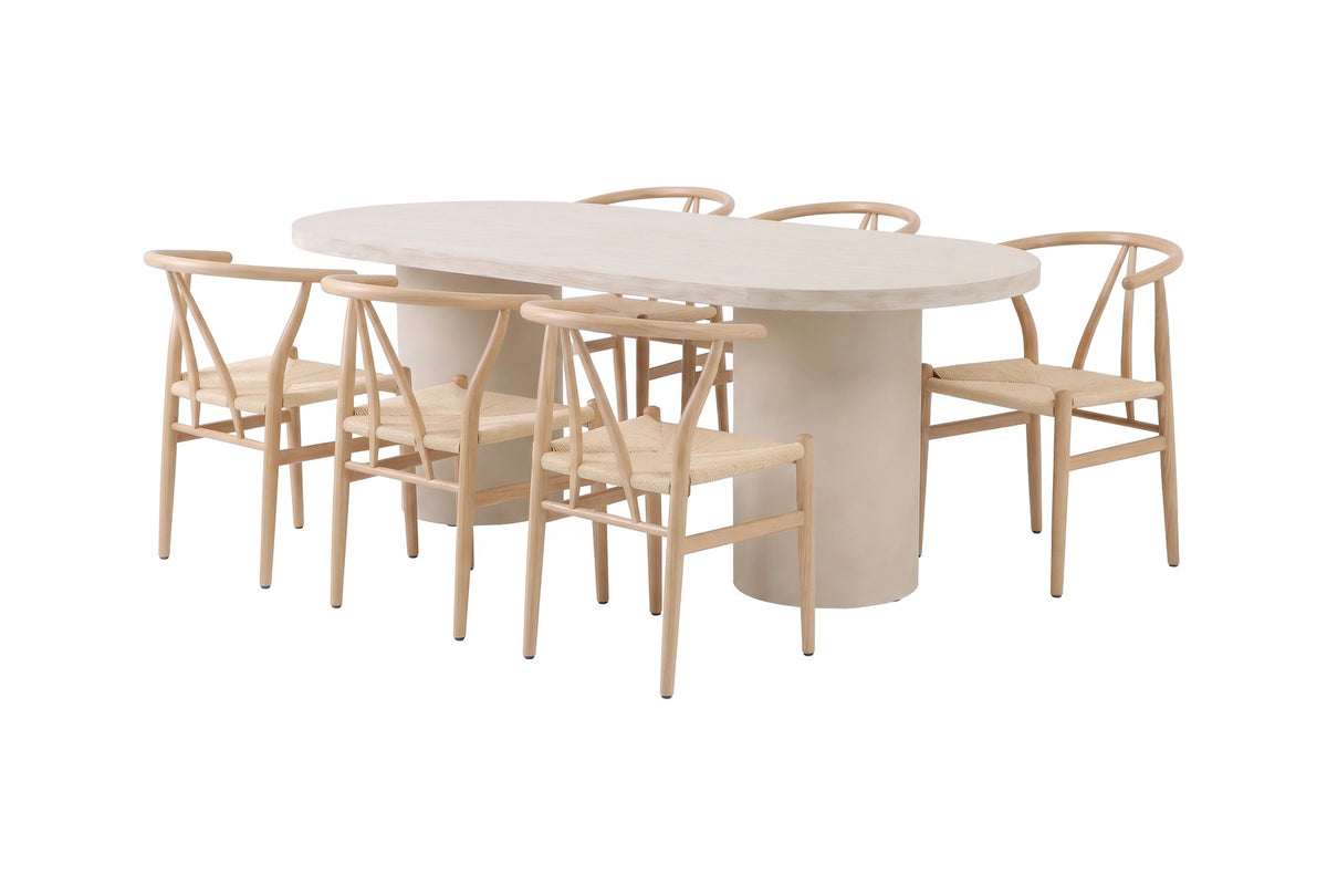 Ovaler Esstisch mit MDF-Tischplatte in Beige und Stahlbeinen, umgeben von stapelbaren Esszimmerstühlen mit Rattan-Geflecht und Stahlgestell in Holzoptik.