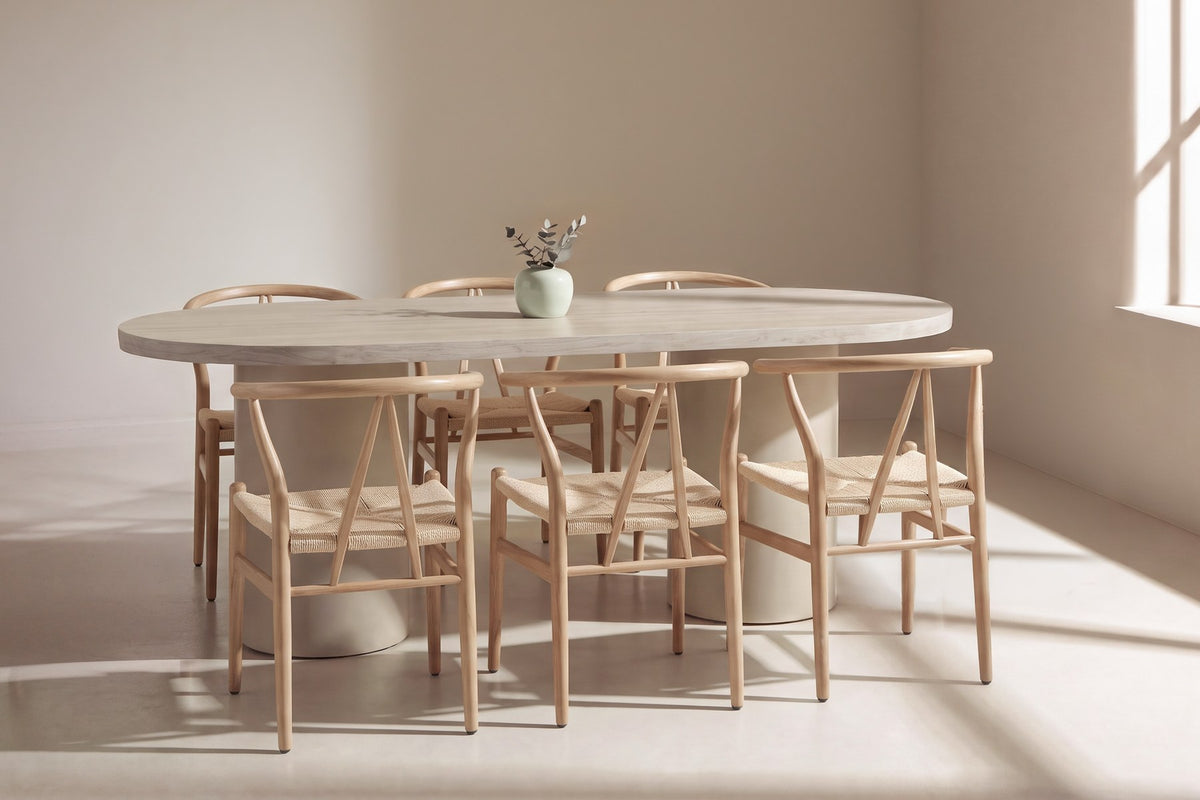 Ovaler Esstisch mit MDF-Tischplatte in Beige und Stahlbeinen, umgeben von stapelbaren Esszimmerstühlen mit Rattan-Geflecht und Stahlgestell in Holzoptik.