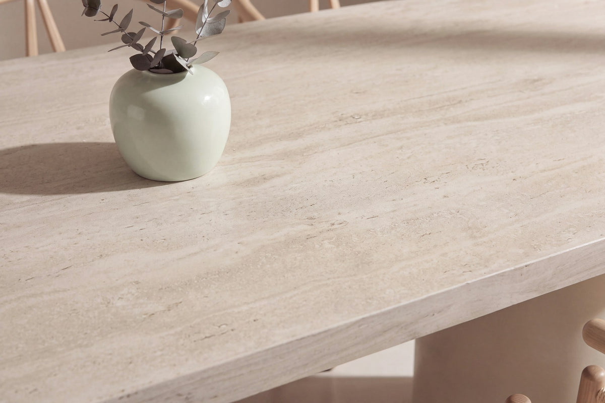 Ovaler Esstisch mit MDF-Tischplatte in Beige und Stahlbeinen, umgeben von stapelbaren Esszimmerstühlen mit Rattan-Geflecht und Stahlgestell in Holzoptik.