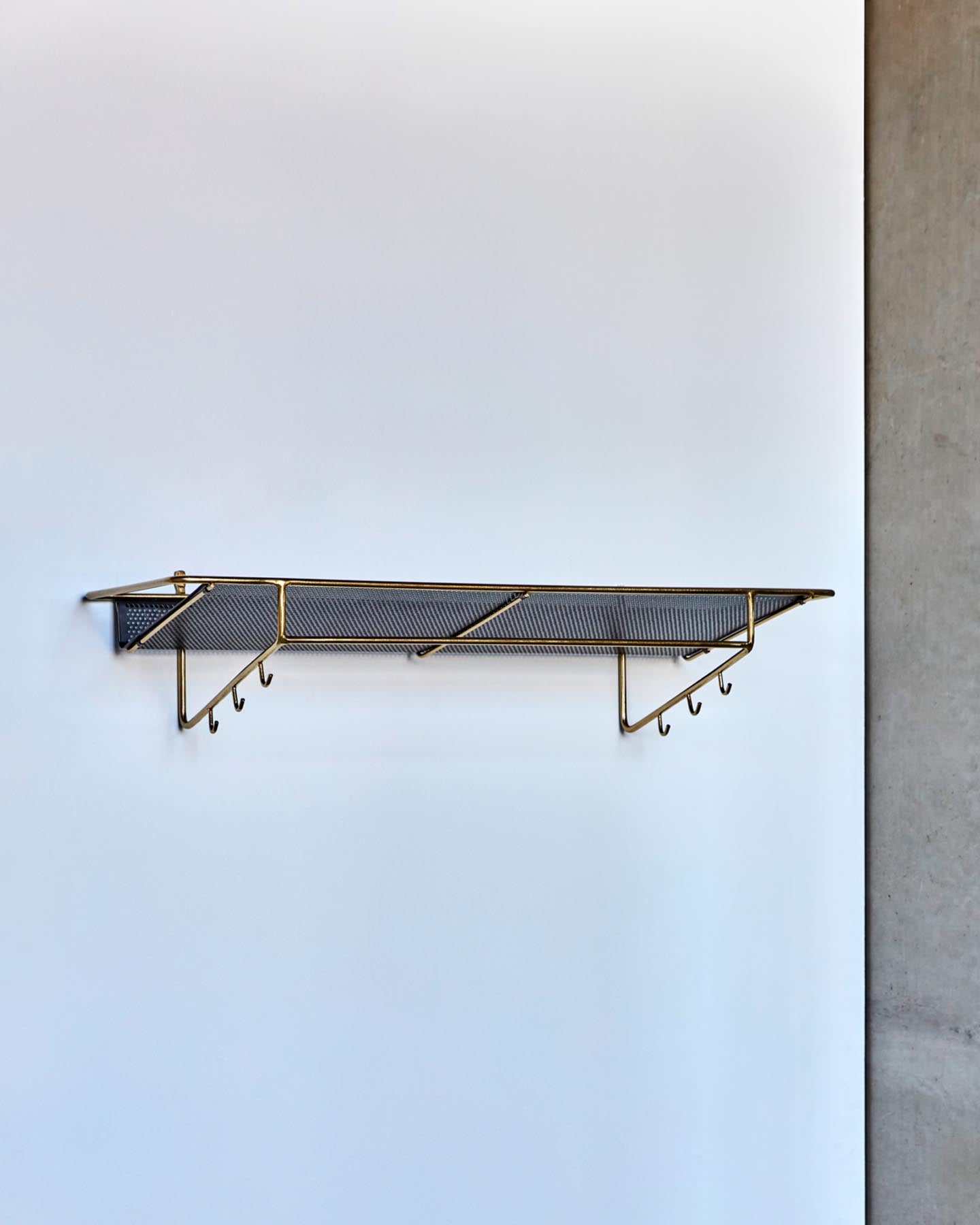 Entdecken Sie das HDWally Wandregal von House Doctor mit elegantem antikem Messing-Finish und schwarzer Ablage – stilvoll und funktional für jedes Zuhause.