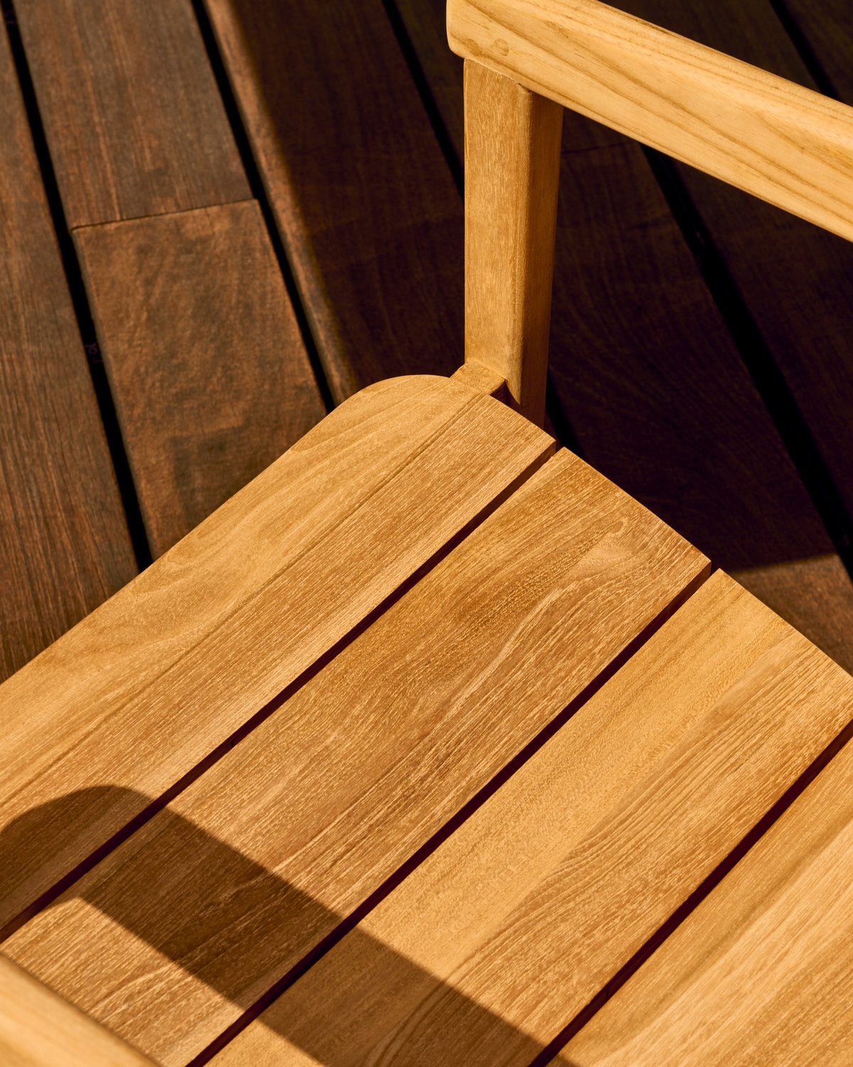 Stapelbarer Stuhl Icaro aus massivem Teakholz mit natürlichem Finish FSC 100% in Natur präsentiert im Onlineshop von KAQTU Design AG. Gartenstuhl mit Armlehnen ist von Kave Home