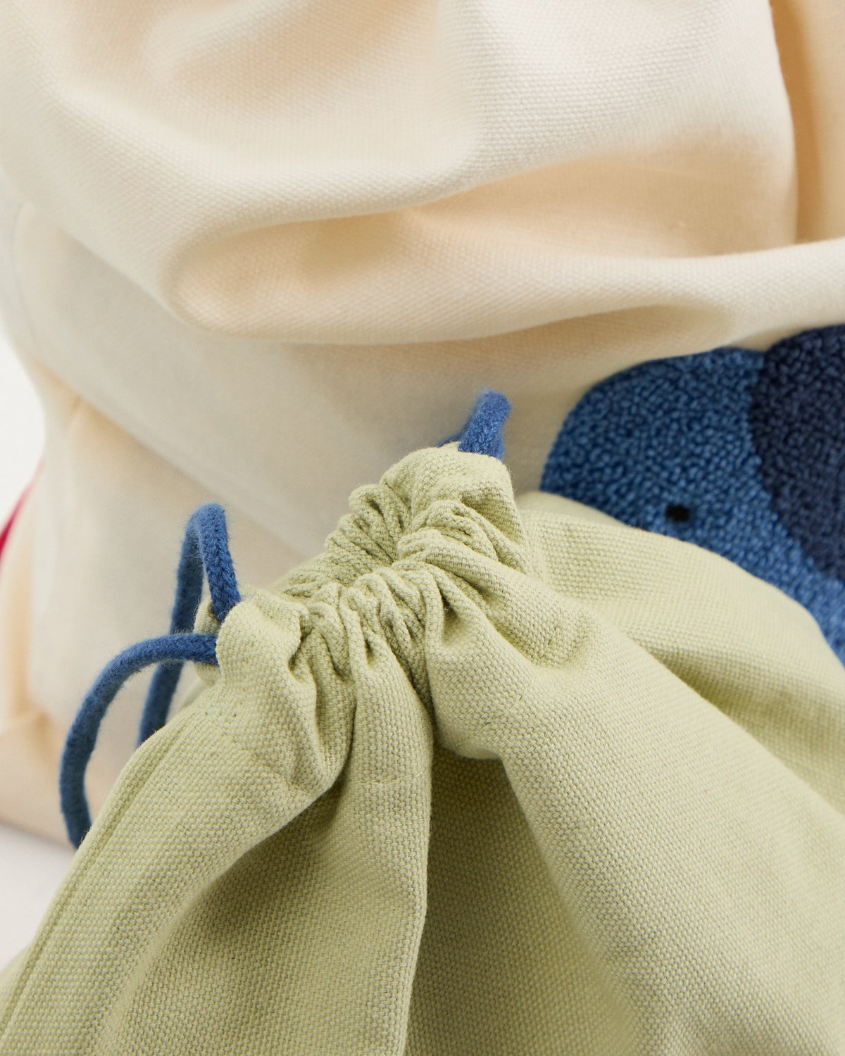 Zwei Taschen aus Baumwolle in Beige und Grün, jede mit einem aufgestickten blauen Elefanten, handgefertigt für Kinder.