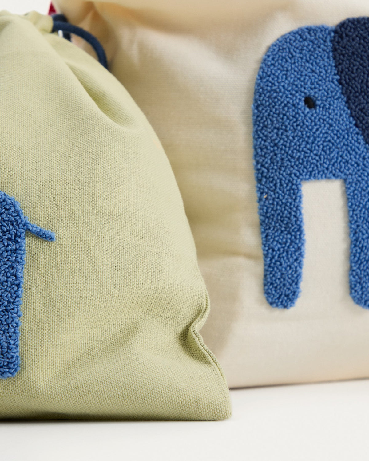 Zwei Taschen aus Baumwolle in Beige und Grün, jede mit einem aufgestickten blauen Elefanten, handgefertigt für Kinder.