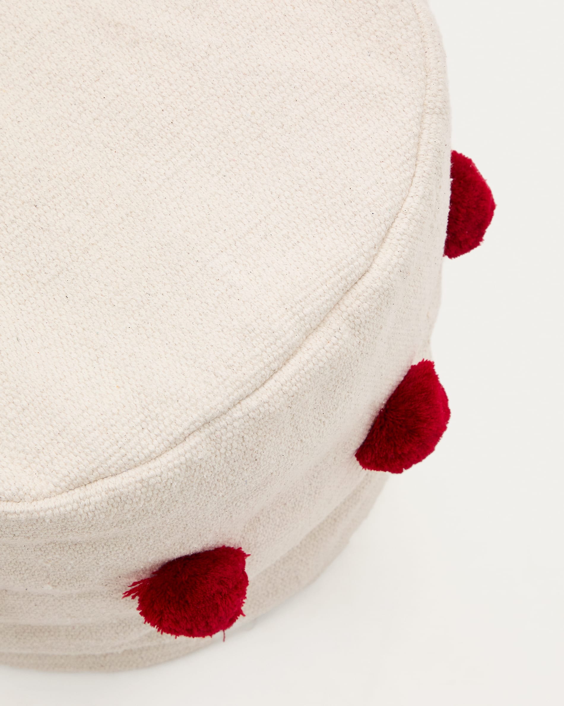 Stylischer Sitzsack Manua von Kave Home aus weicher Baumwolle in Beige mit roten Quasten. Perfekt für Kinder und vielseitig einsetzbar.