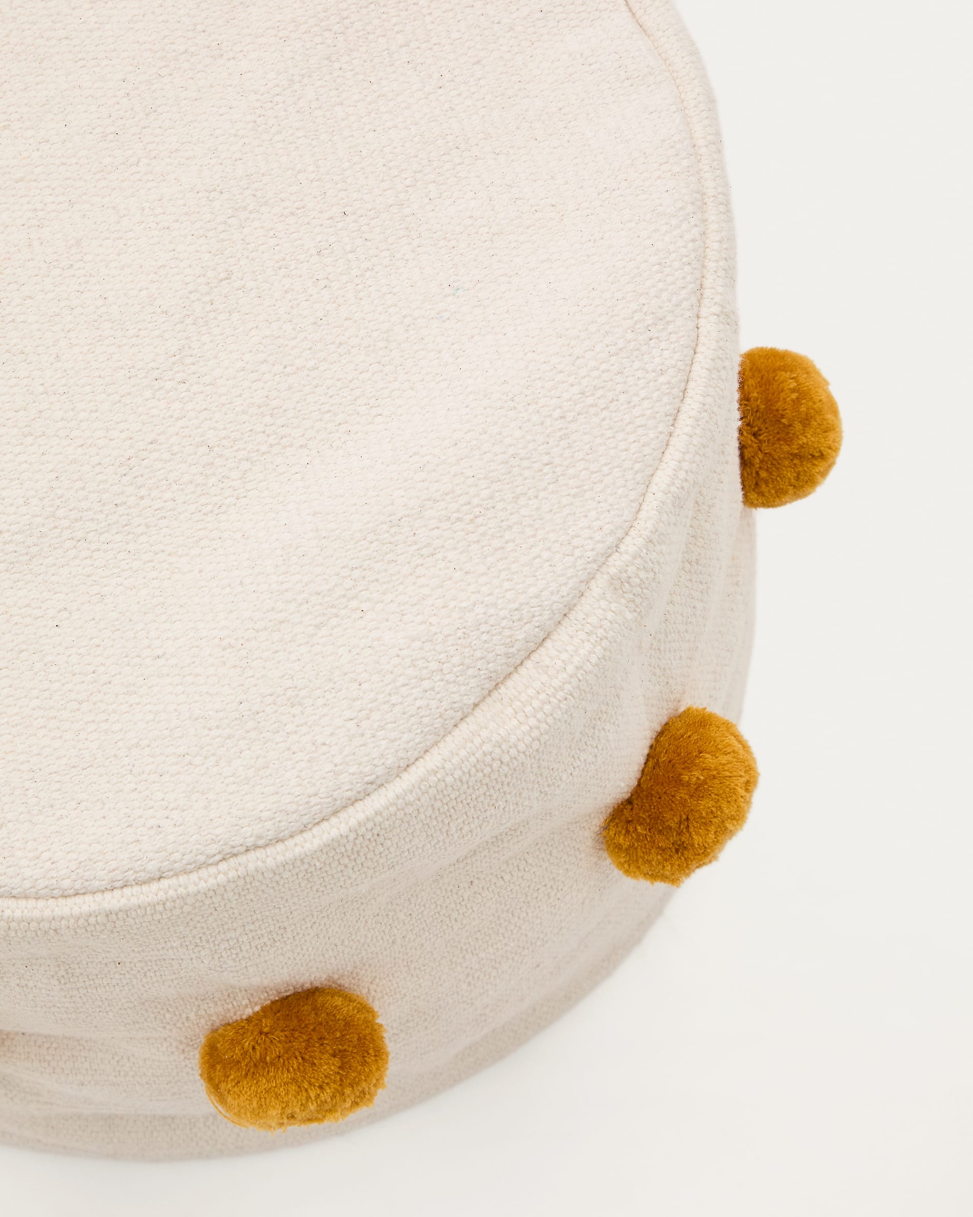 Sitzsack Manua von Kave Home: Bequemer Baumwollsitzsack in sanftem Beige mit verspielten senffarbenen Quasten. Ideal für Kinderzimmer und kreative Spielbereiche.