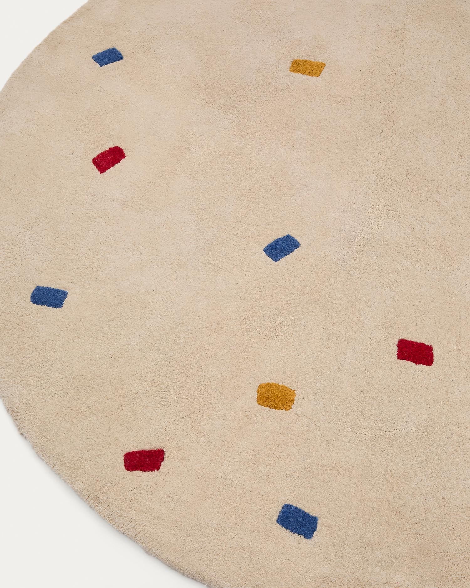 Der Teppich Luli von Kave Home bringt mit bunten Punkten auf weißem Grund Freude ins Kinderzimmer. Aus 100% Baumwolle, Ø 120 cm, pflegeleicht und bequem.