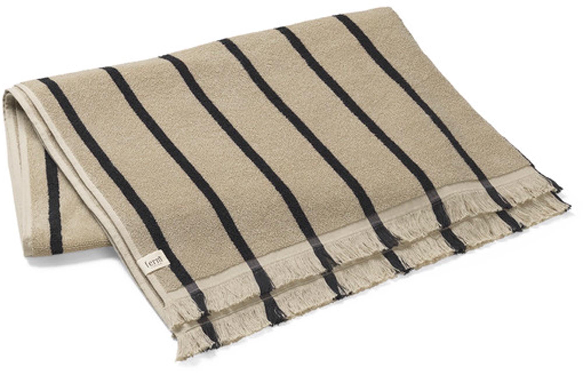 Entdecken Sie das Alee Strandtuch von Ferm Living: 100% GOTS-zertifizierte Bio-Baumwolle, weich, saugfähig, stilvolles Design mit Fransen. Perfekt für Strand und Schwimmbad!