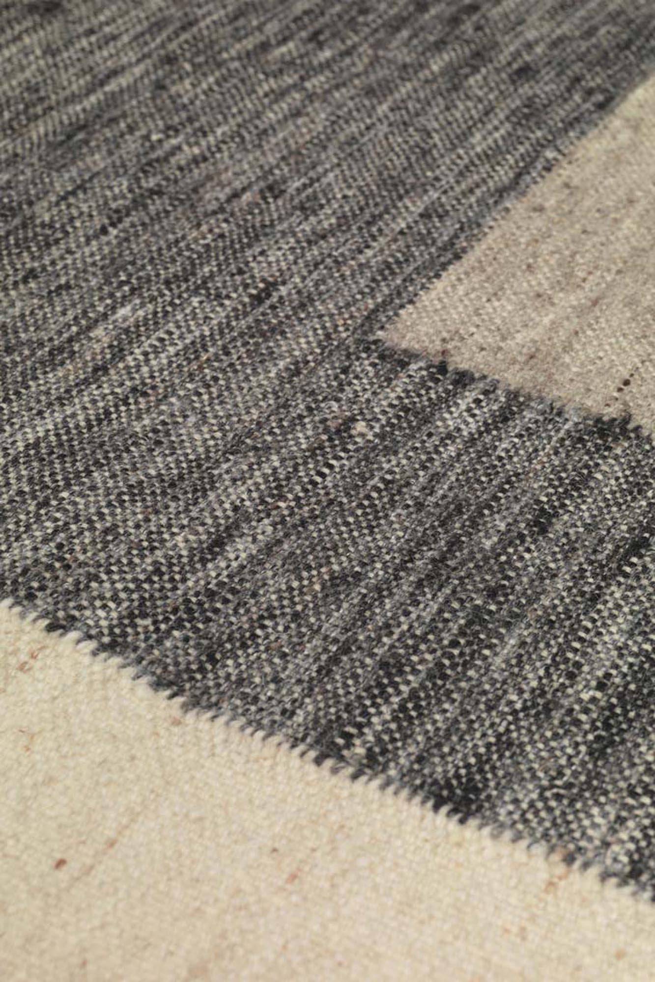 Asymmetrischer Teppich von Ferm Living aus 100% Wolle, handgewebt und mit Chambray-Fransen für stilvolle Akzente in jedem Raum.