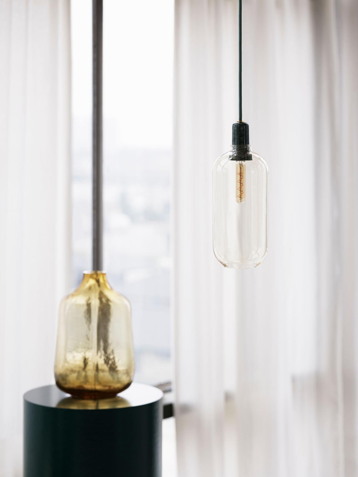 Entdecken Sie die Amp Lampe groß EU von Normann Copenhagen – eine stilvolle Pendelleuchte aus Marmor und Glas, die nostalgisches Flair mit modernem Design vereint.