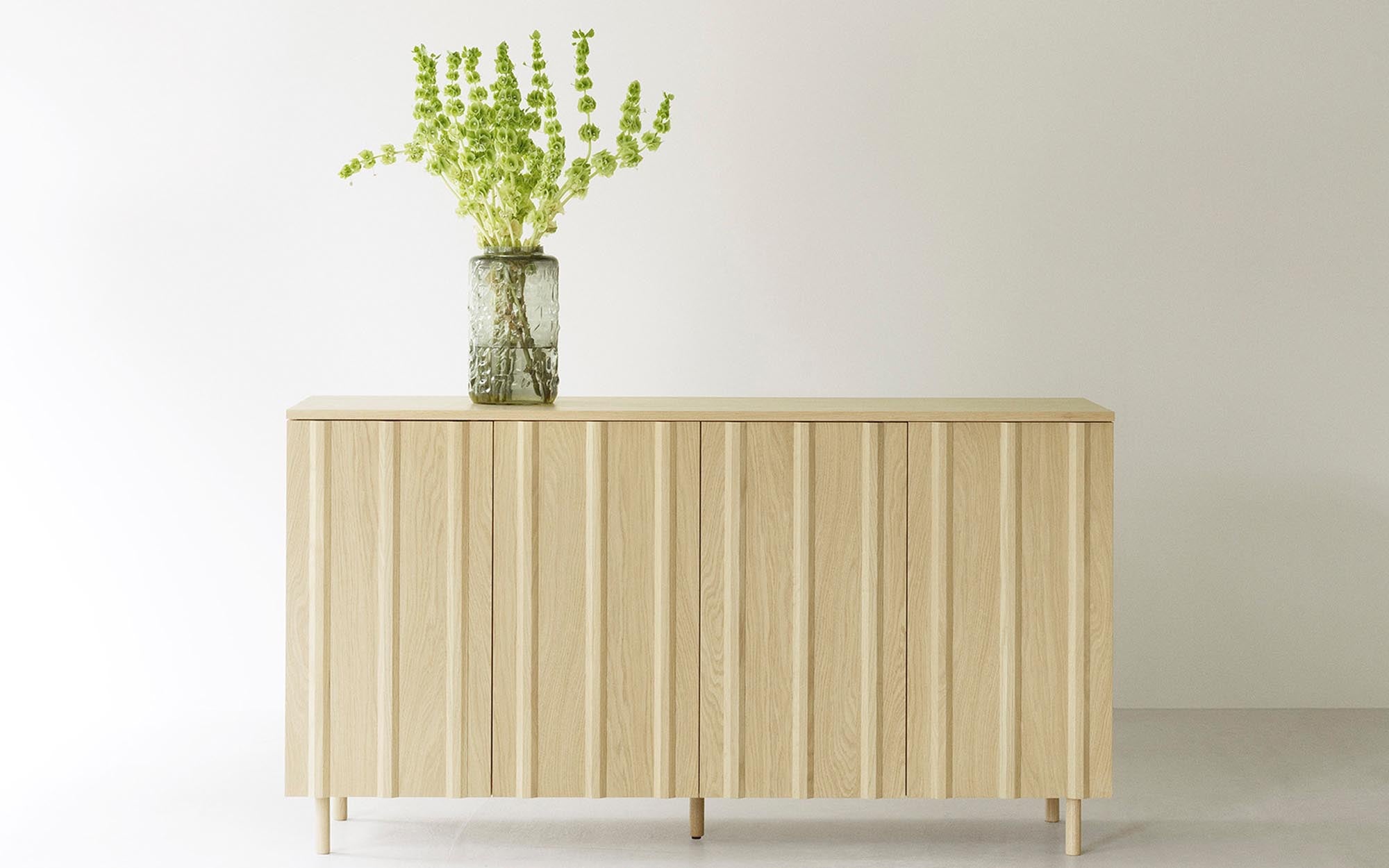 Das Rib Sideboard von Normann Copenhagen kombiniert zeitloses skandinavisches Design mit praktischer Funktionalität. Die charakteristischen Holzpaneele und die hochwertige Verarbeitung machen es zum idealen Möbelstück für jeden Raum.