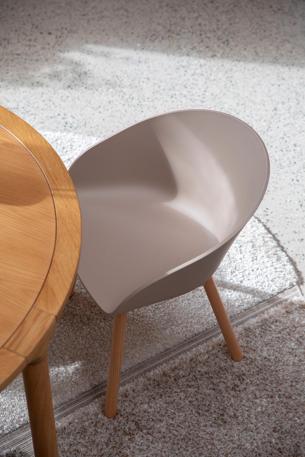 Kompakter Void Sessel von Zuiver, aus 90% recyceltem Kunststoff und natürlicher Eiche, vereint Komfort und Nachhaltigkeit.