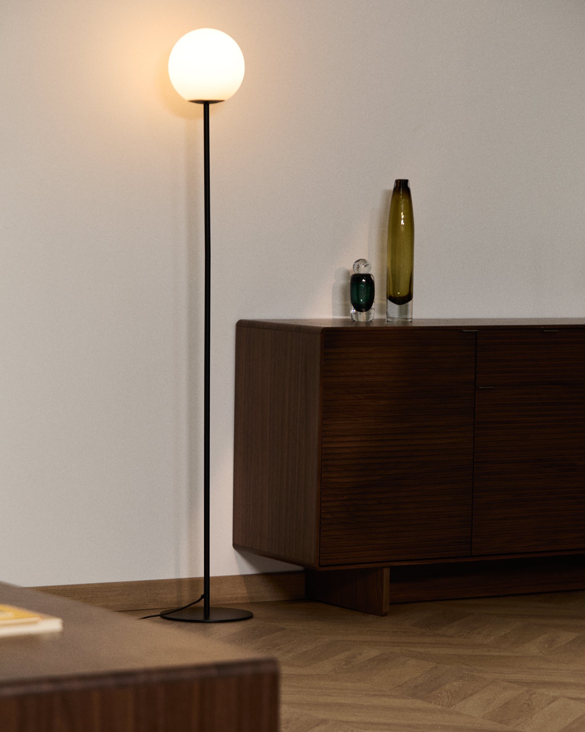 Stehlampe Brisia aus Metall mit schwarzem Finish und einer Glaskugel Ø20 cm in Schwarz präsentiert im Onlineshop von KAQTU Design AG. Stehleuchte ist von Kave Home