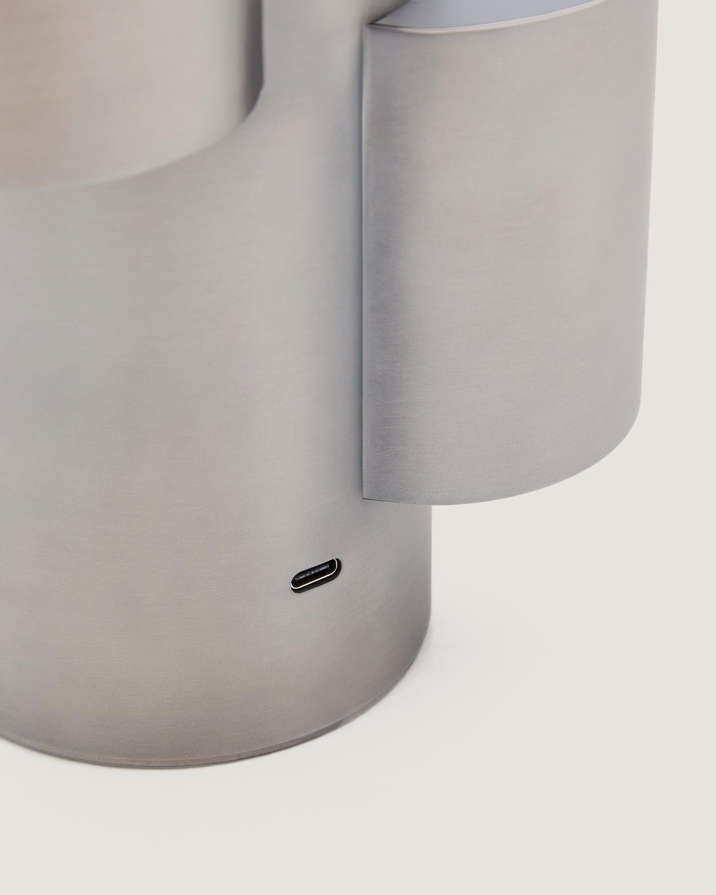 Tragbare LED-Tischlampe Adrina aus hellgrauem Metall mit gebürstetem Finish in Silber präsentiert im Onlineshop von KAQTU Design AG. Tischleuchte ist von Kave Home
