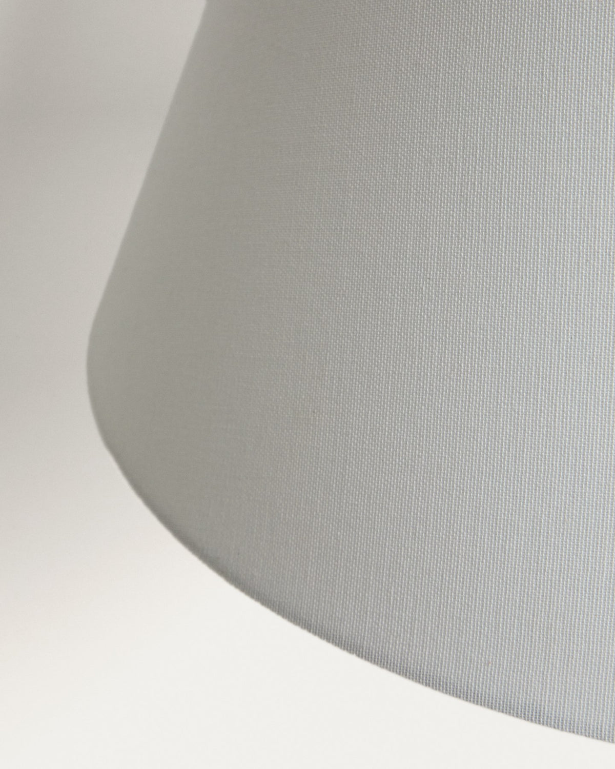 Stehlampe aus Metall mit silbernem, gebürstetem Finish und konischem Lampenschirm aus Baumwollstoff in gebrochenem Weiss, mit Stahlsockel.